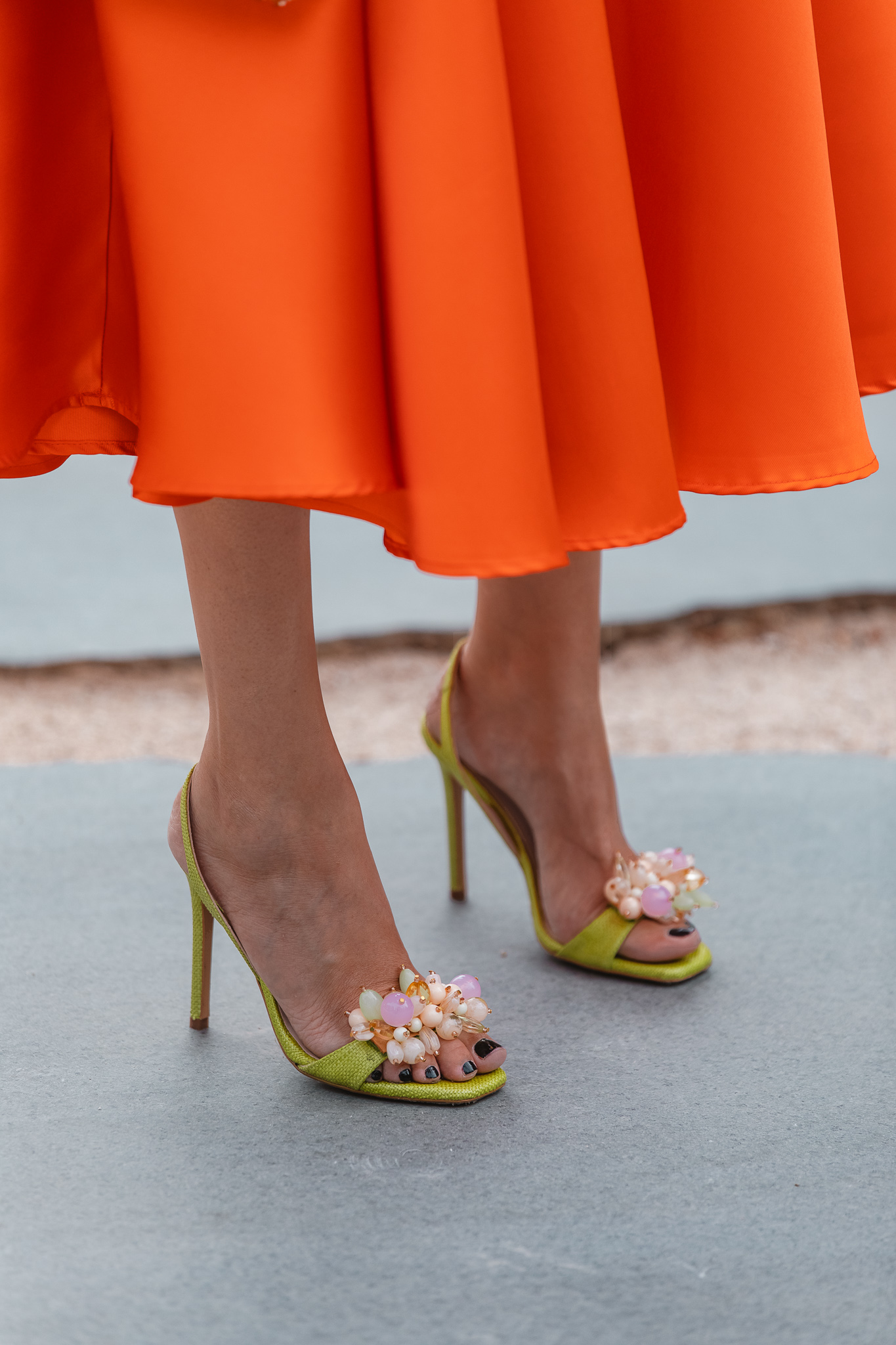 Sandalias en color lima de Lodi combinadas con falda naranja de invitada