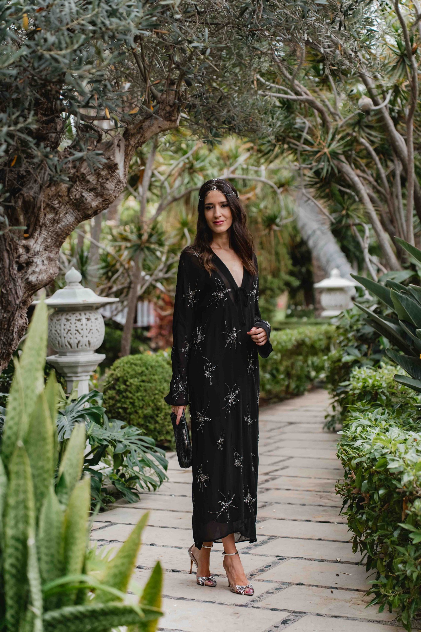 Look completo de invitada boho con vestido negro y tocado casquete en el Hotel Botánico de Tenerife.