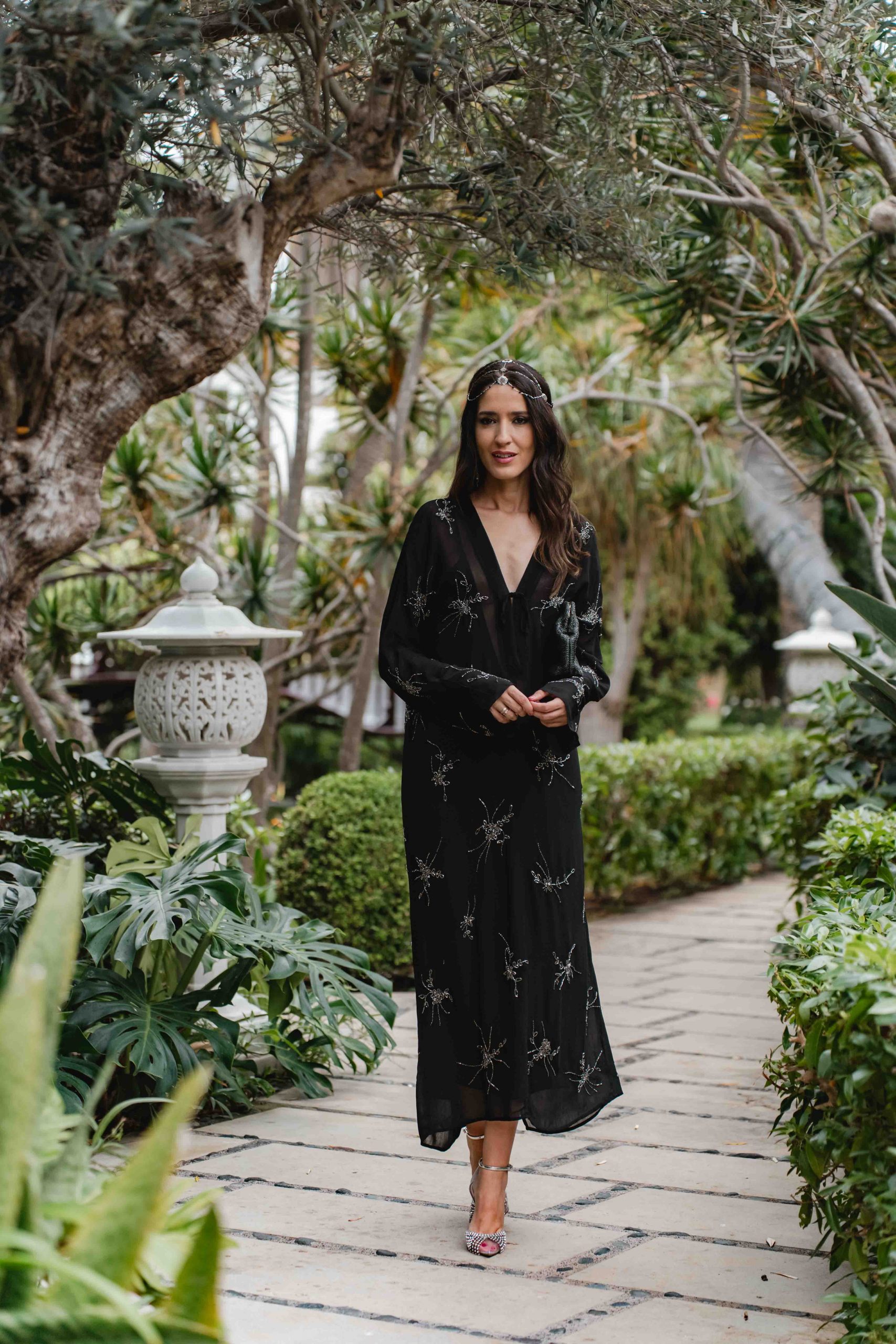Look invitada de boda boho con vestido negro y casquete