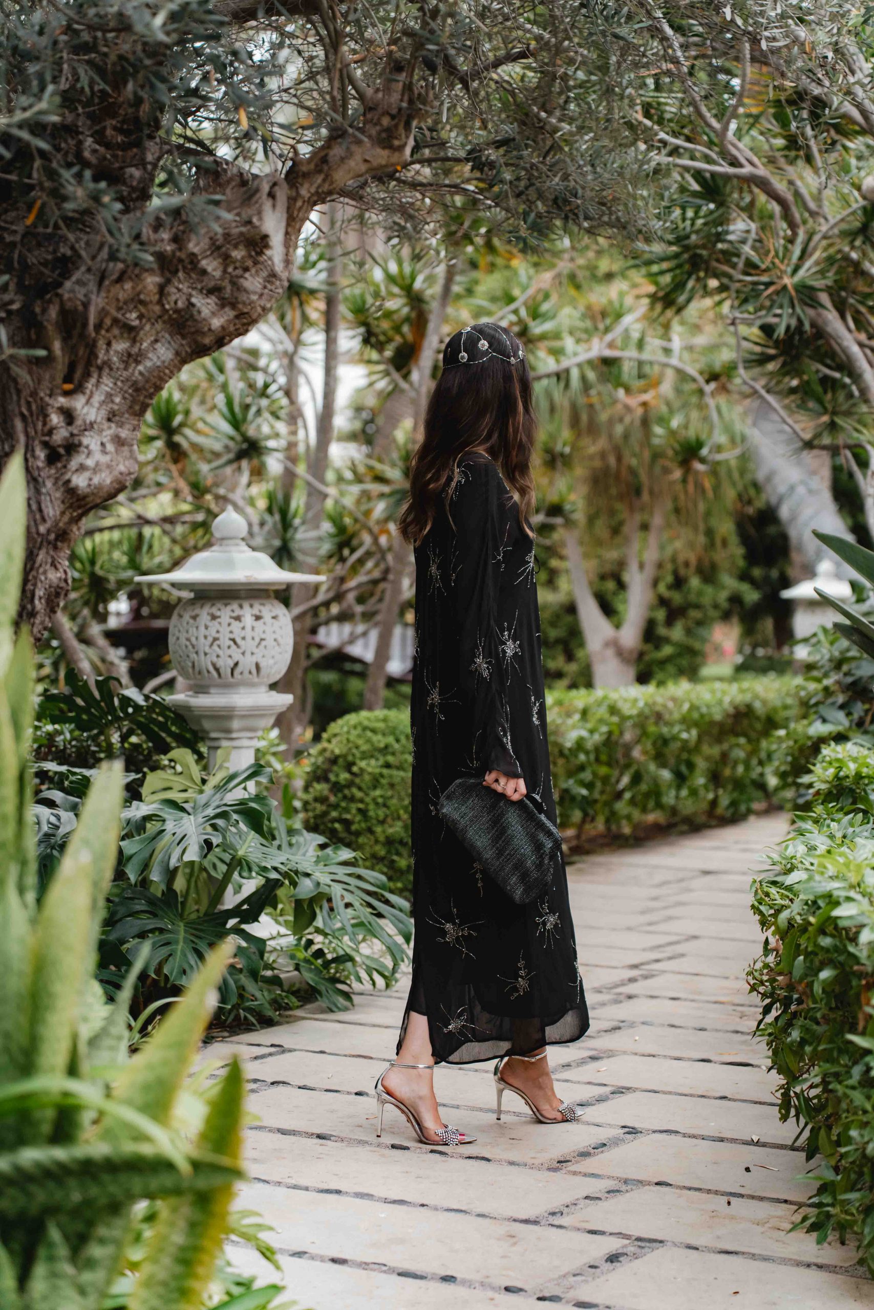 Lateral del look de invitada boho con vestido negro de Massimo Dutti con casquete