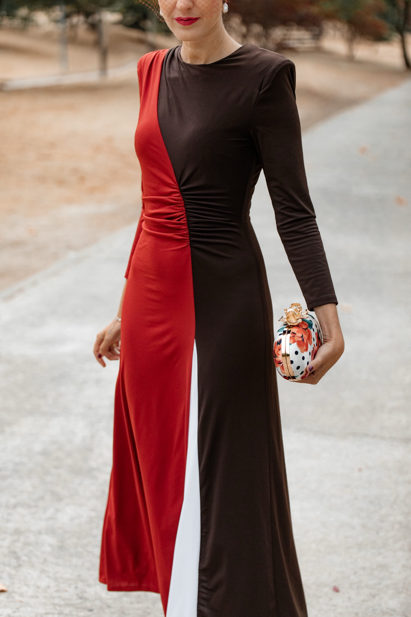 Detalle del vestido de invitada para boda de otoño rojo, blanco y marrón de Cayro