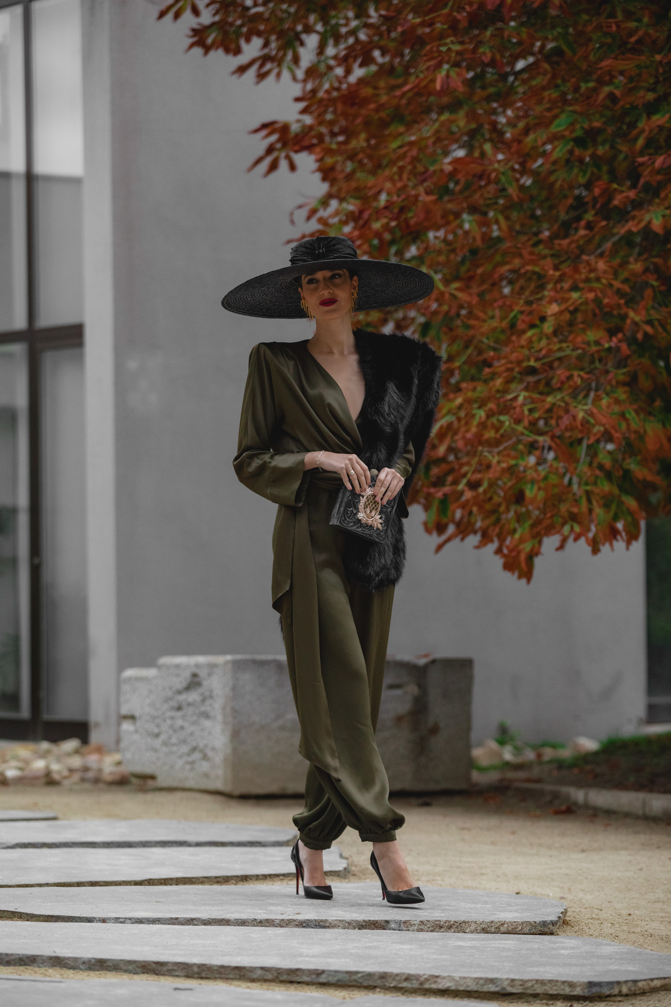 Invitada perfecta con mono verde de Zara y estola de pelo negro.