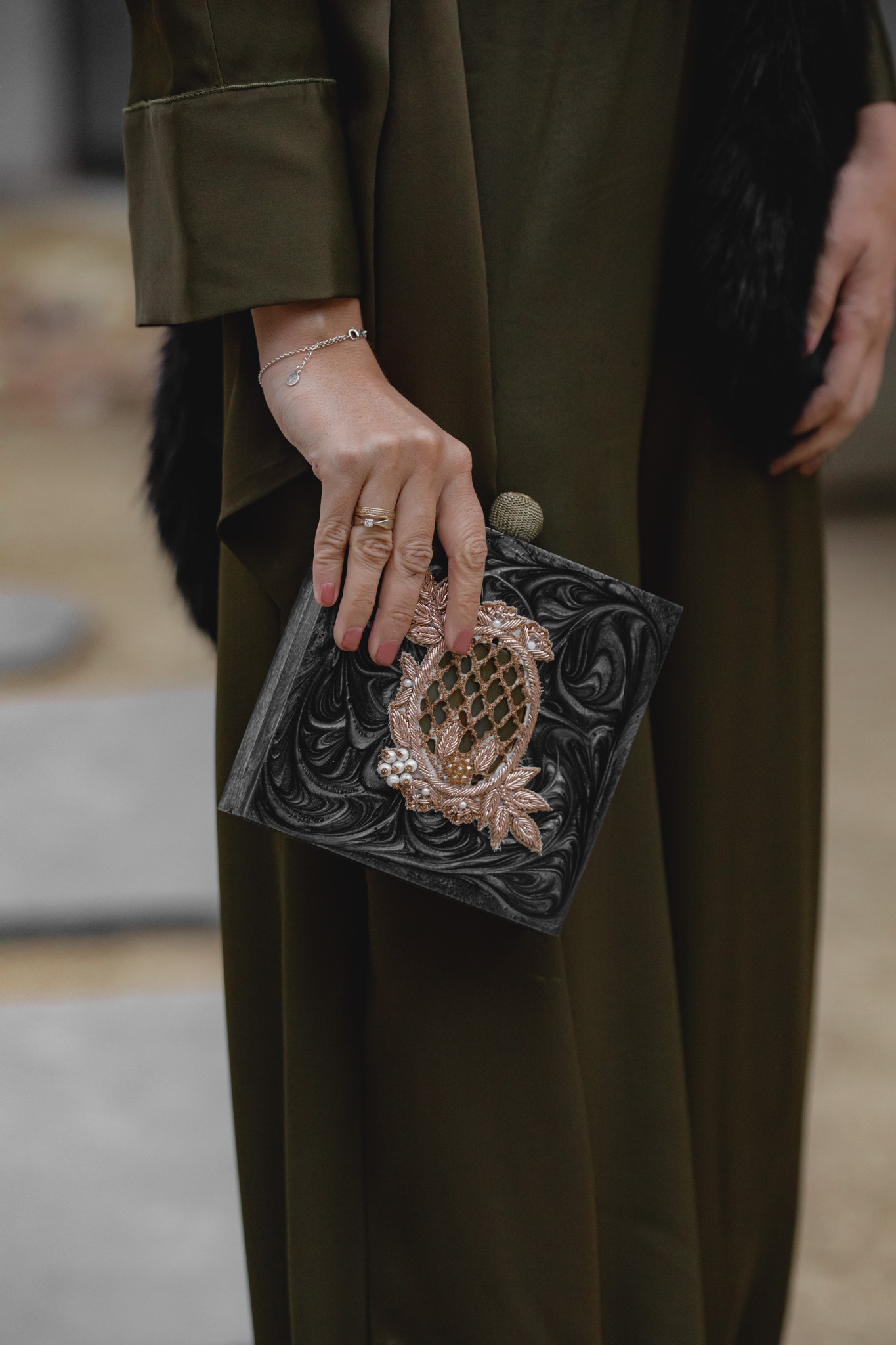 Clutch negro de Occeanis y salones de Louboutin para look de invitada