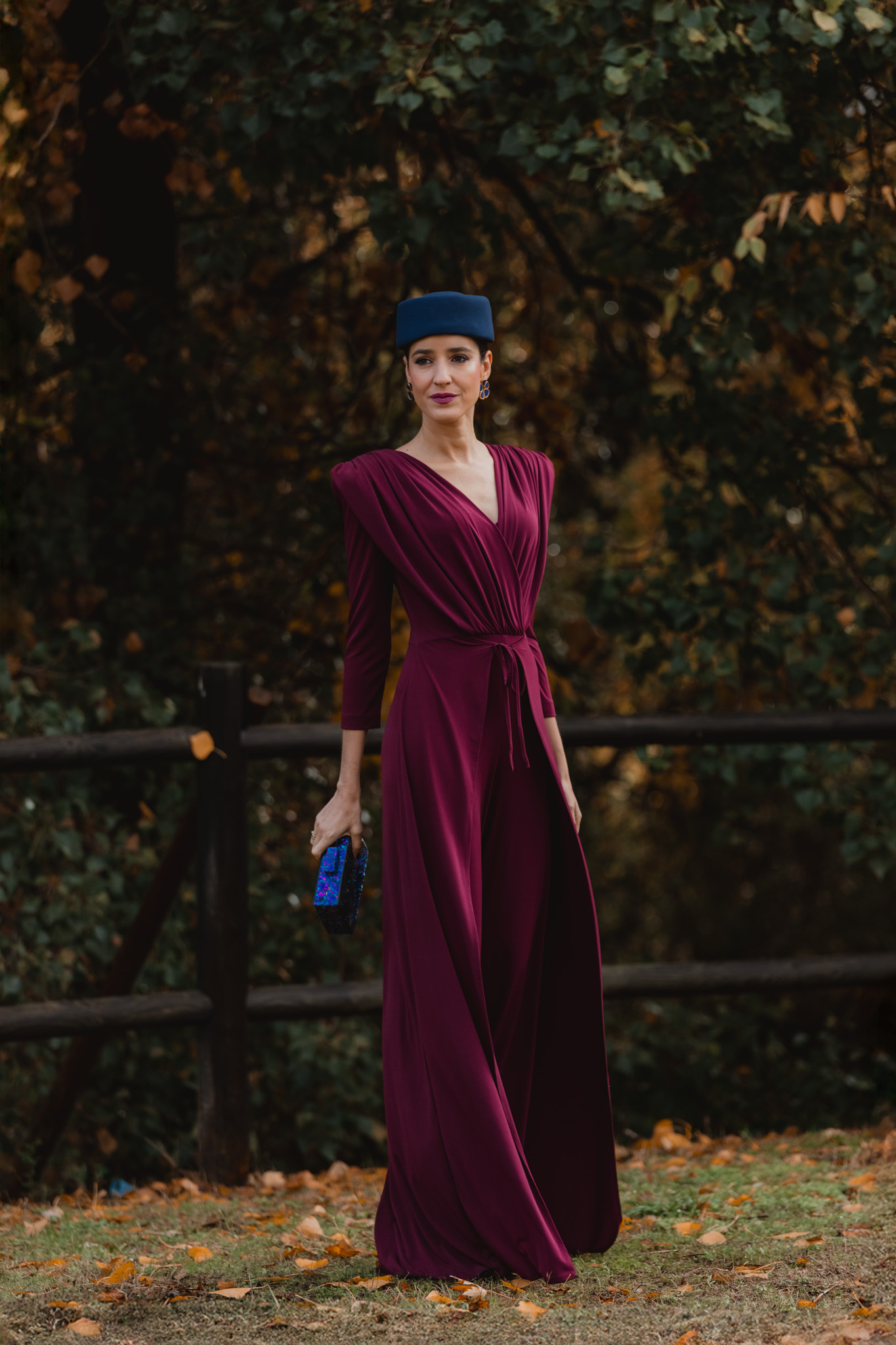 Accesorios azules combinados con jumpsuit burdeos para invitada