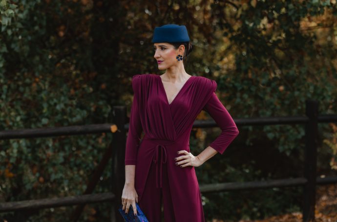 Invitada sujetando bolso rígido nácar morado y azul