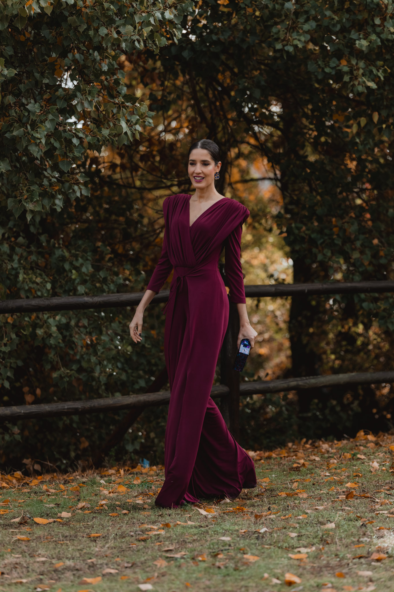 Invitada con jumpsuit de pantalón y sobrefalda lateral en movimiento