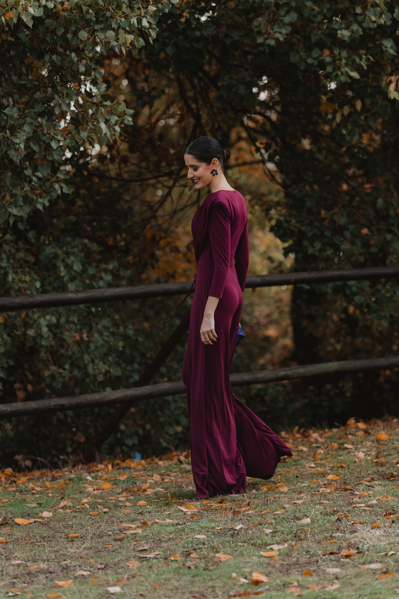 Invitada en entorno natural con jumpsuit burdeos de invierno