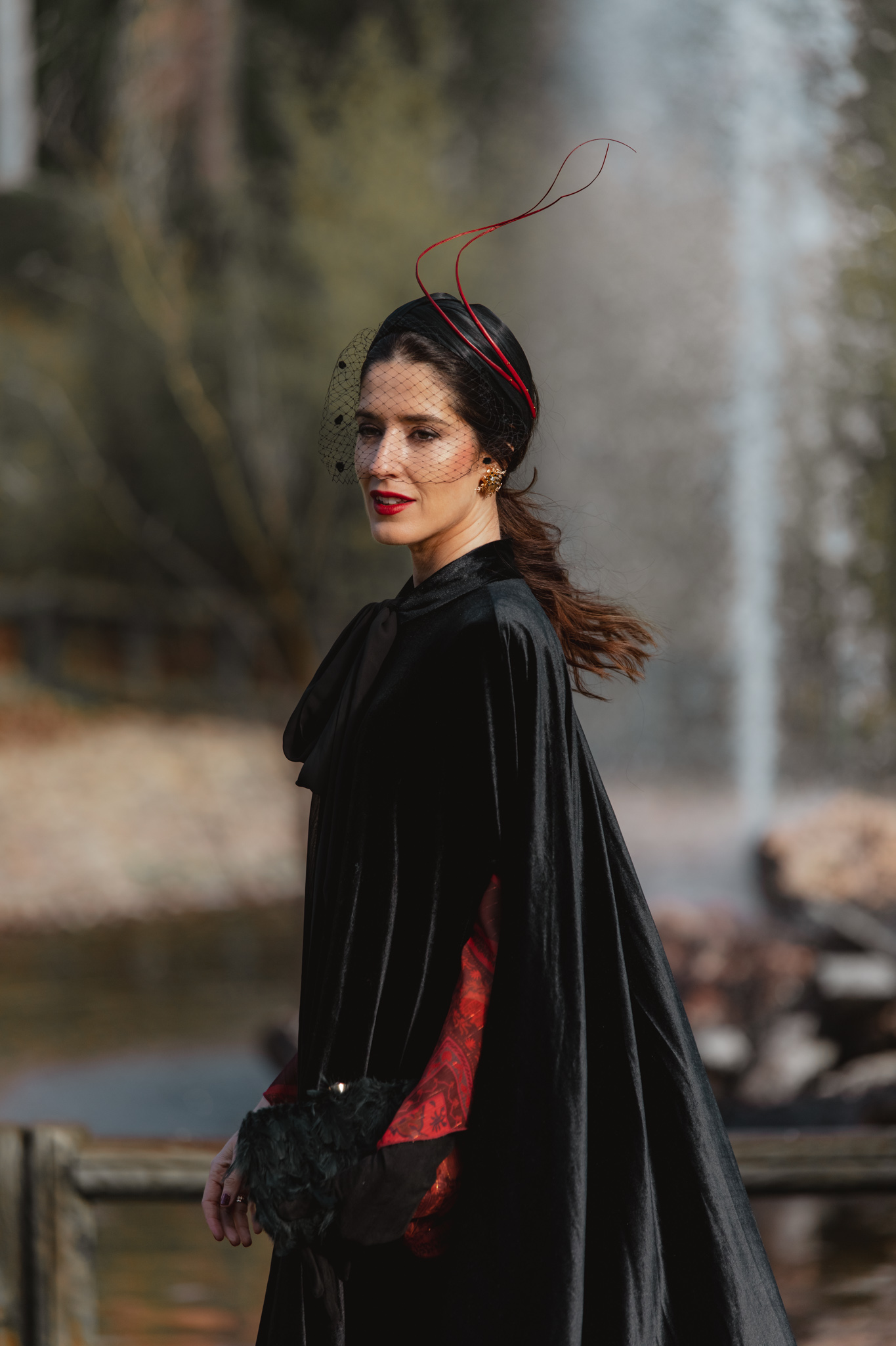 Invitada elegante para boda de mañana en invierno con vestido rojo y capa negra