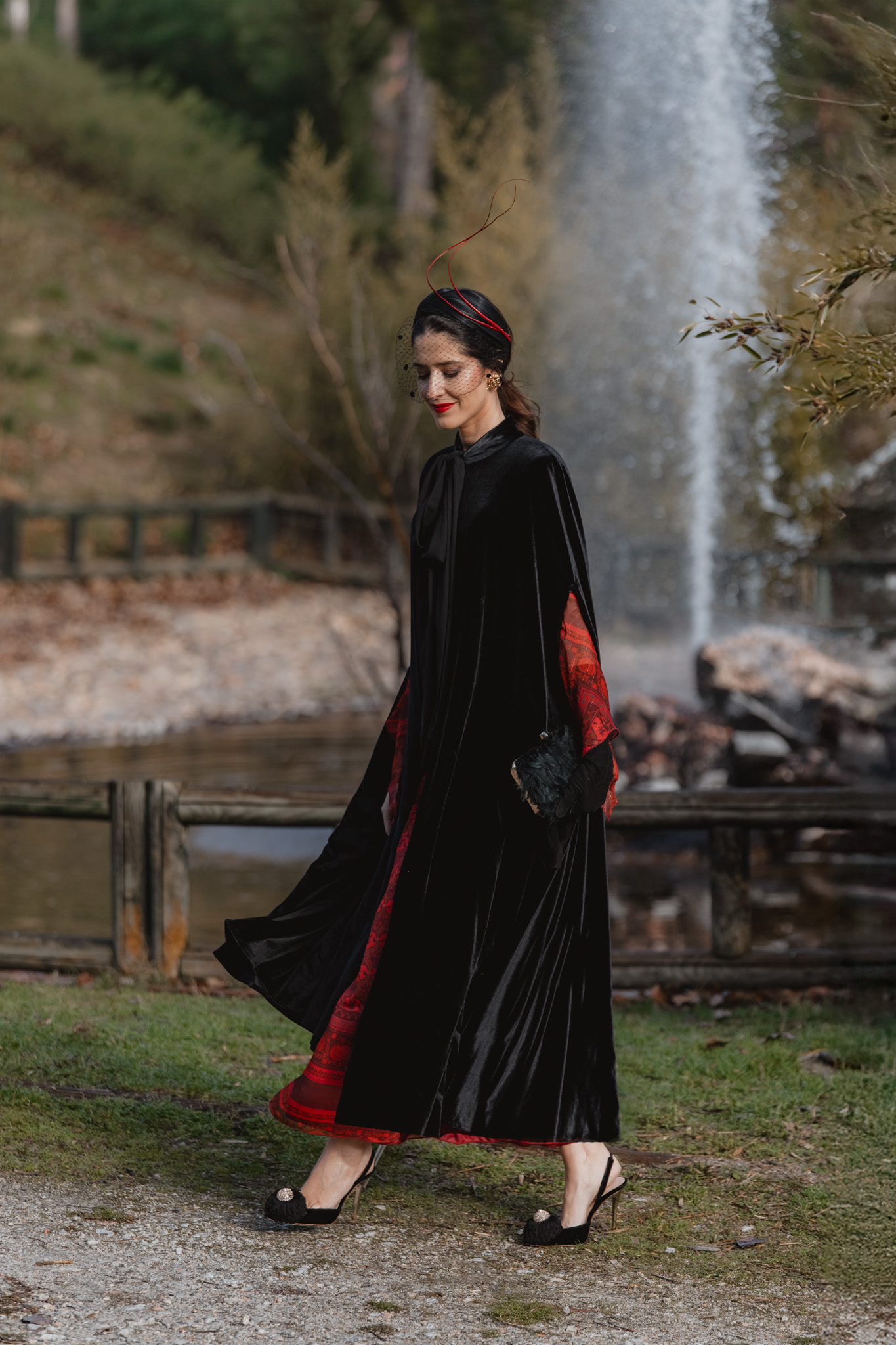 Look de invitada de invierno ideal para bodas al aire libre con vestido rojo y capa de terciopelo