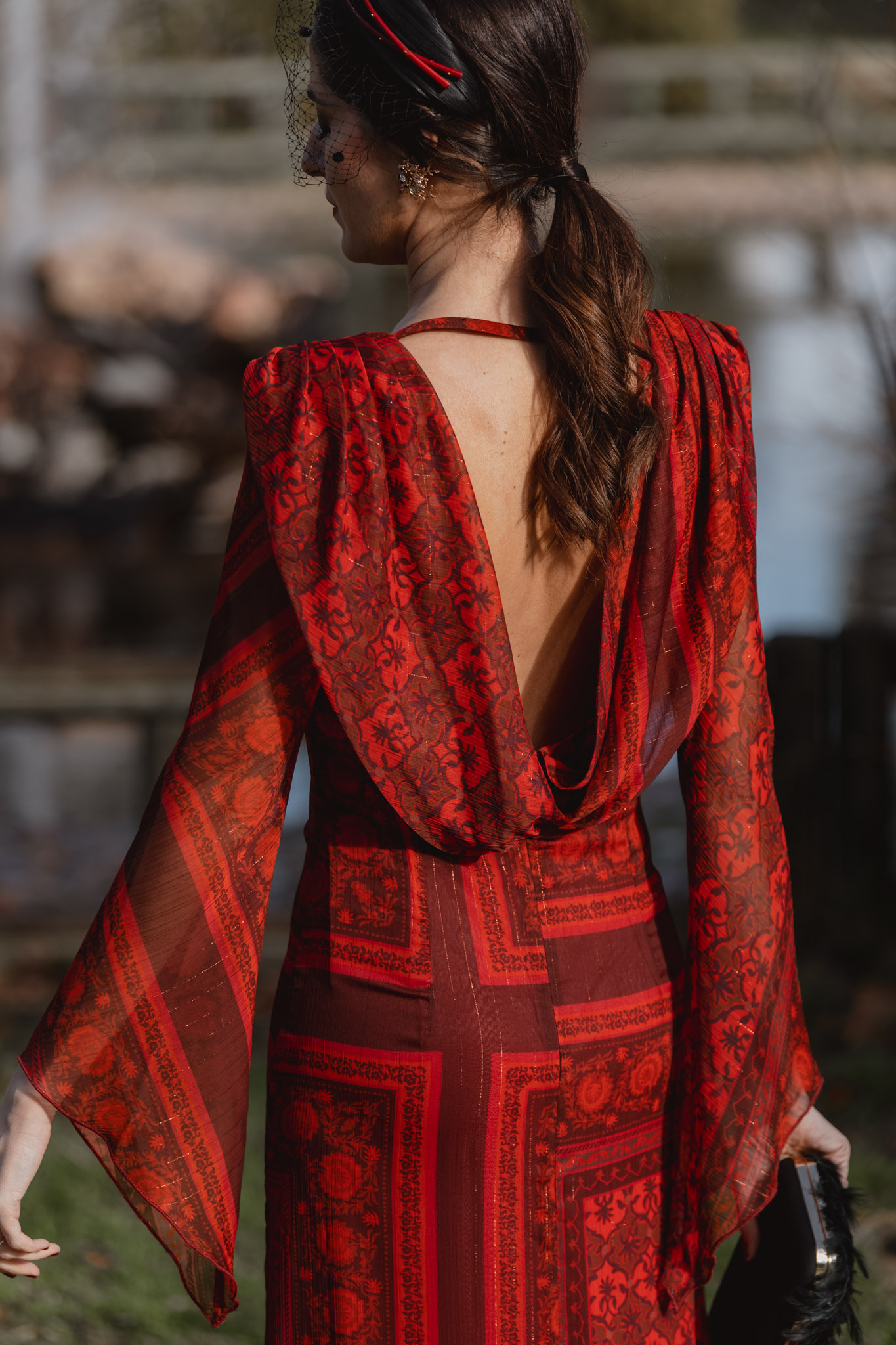 Detalle de la espalda de vestido largo rojo de invitada de invierno con estampado elegante
