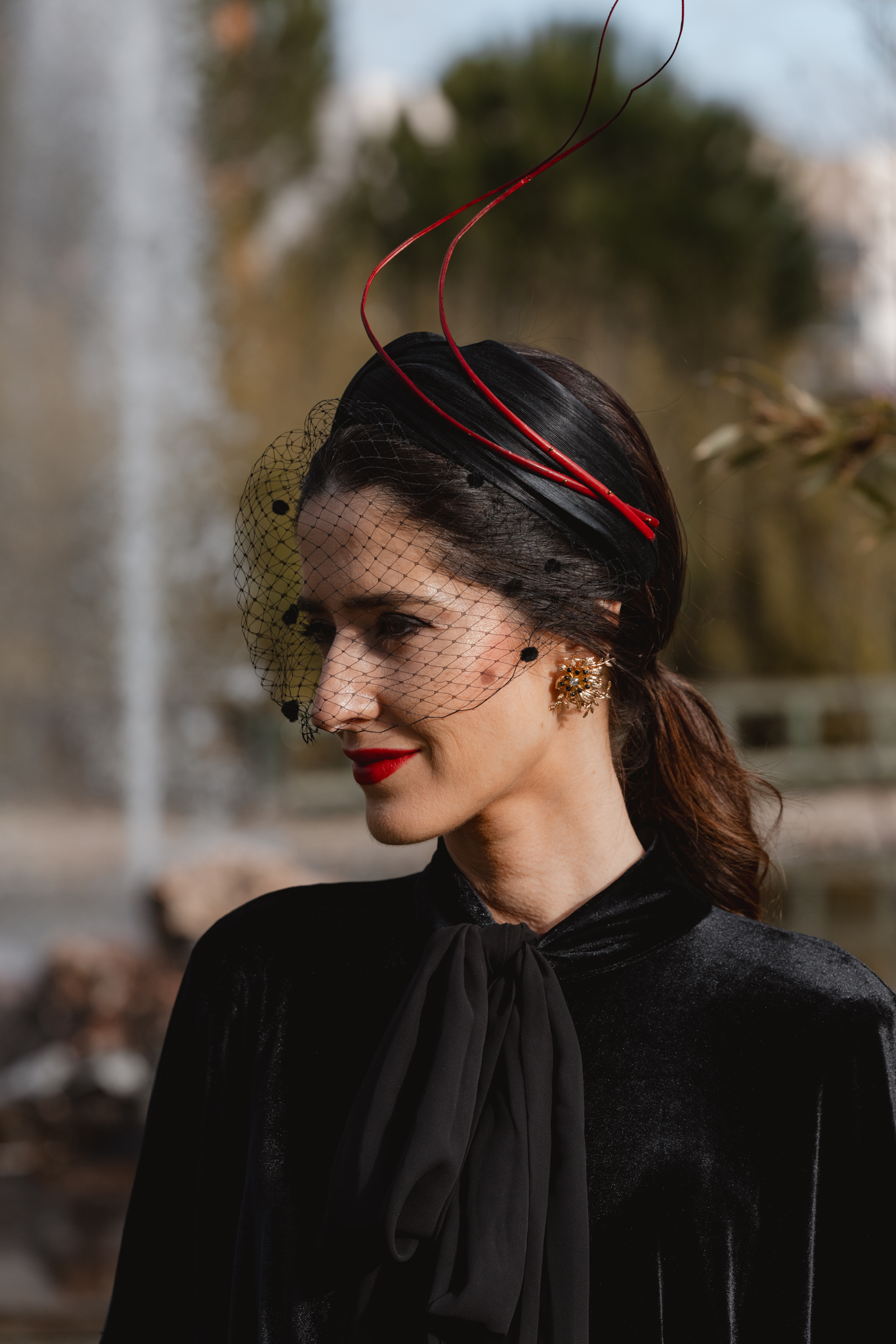 Pendientes dorados para look de invitada de invierno con vestido rojo