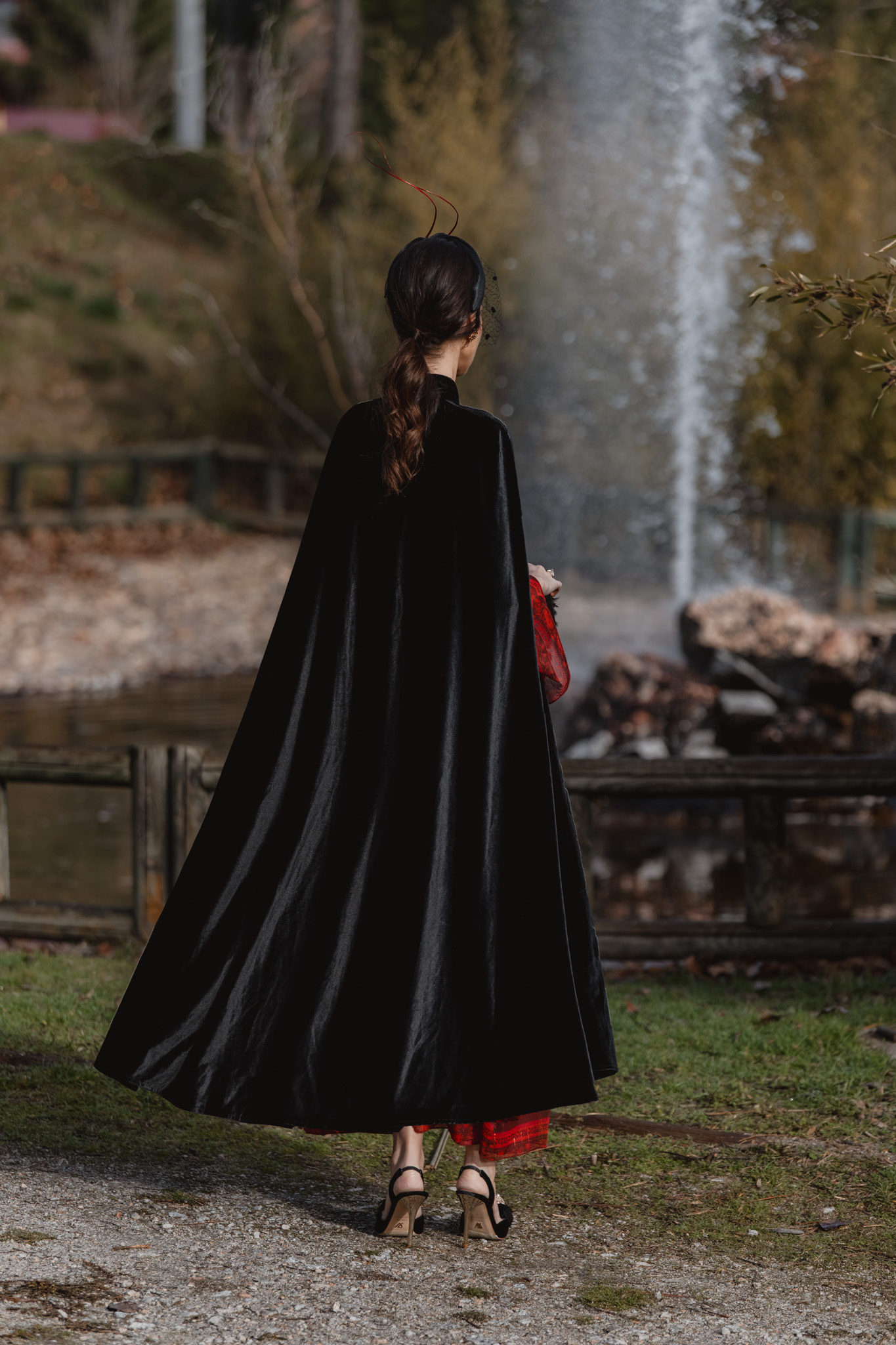 Invitada elegante para boda de invierno con vestido rojo y capa