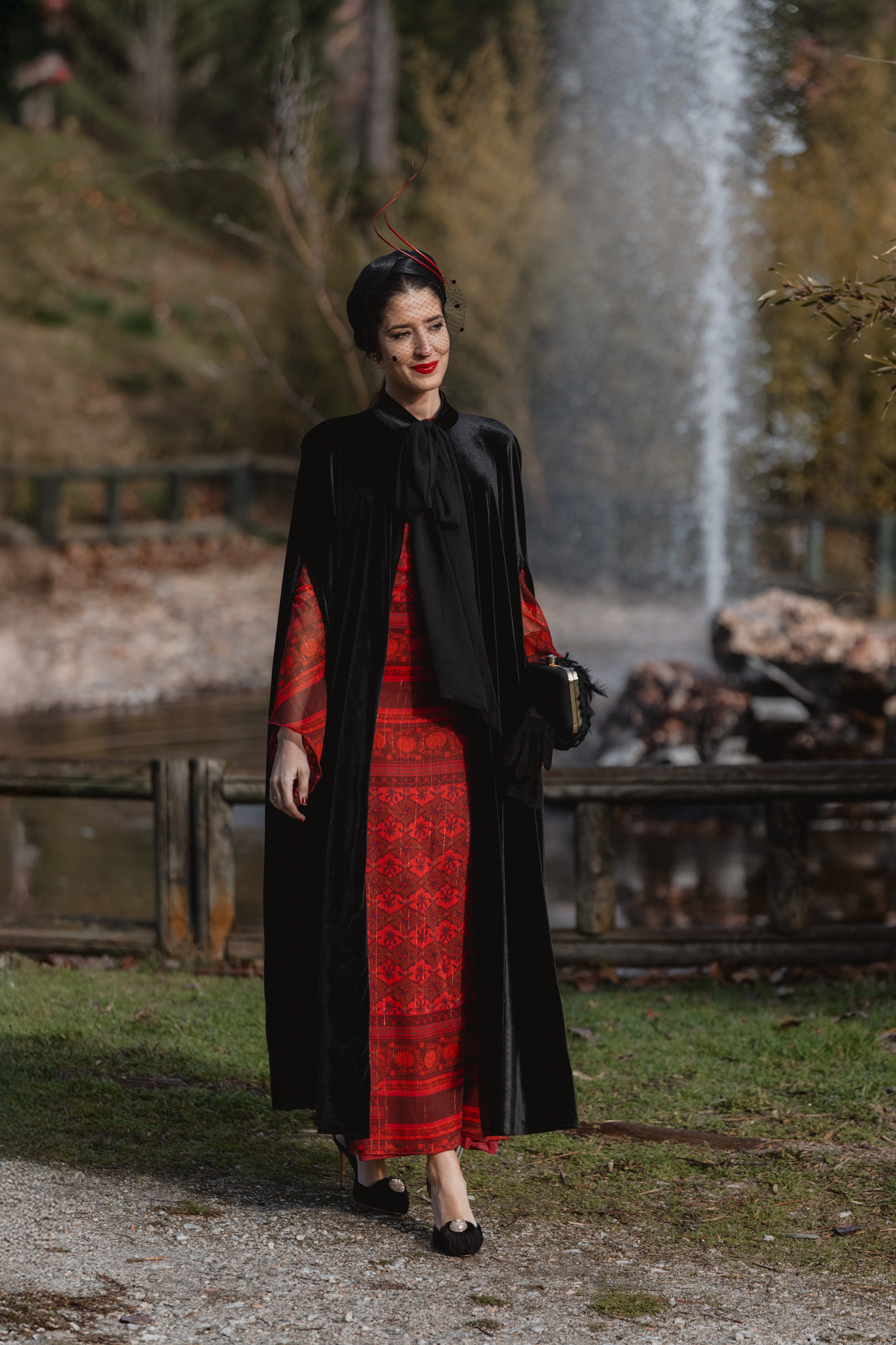 Vestido rojo de invitada de invierno combinado con capa de terciopelo negro