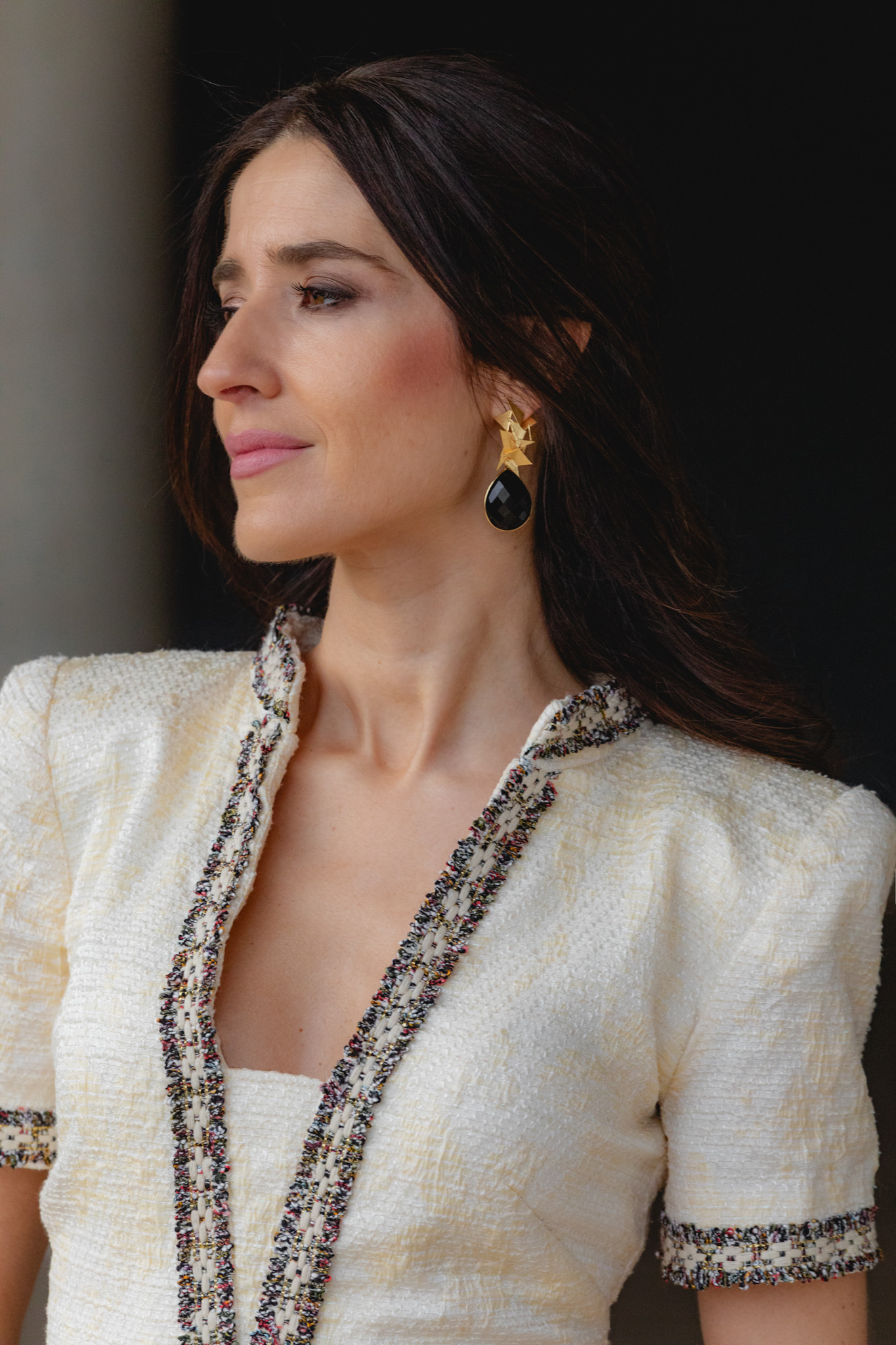 Primer plano del pendiente negro con diseño dorado de Acus Complementos.