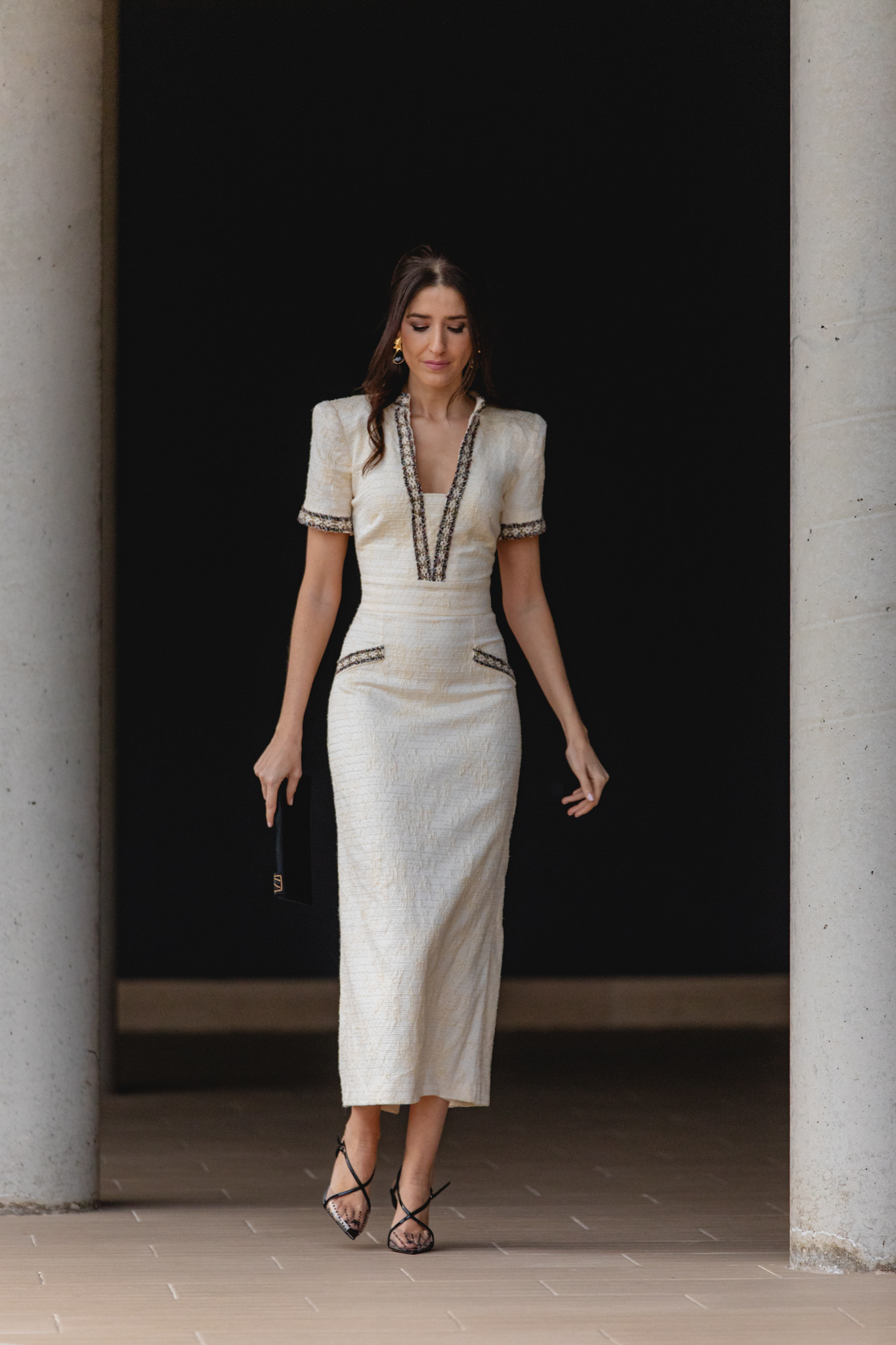 Look de comunión en tonos pastel con accesorios negros elegantes.