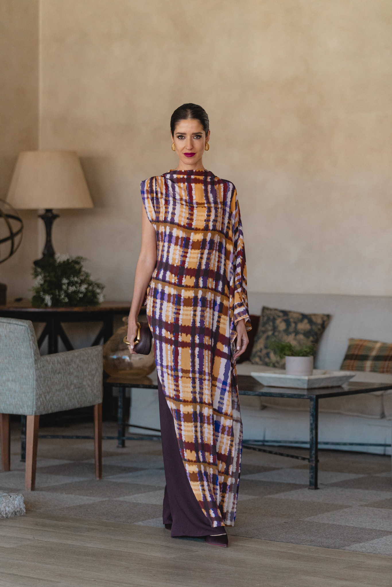 Look de invitada con blusón estampado y pantalón berenjena en espacio cálido