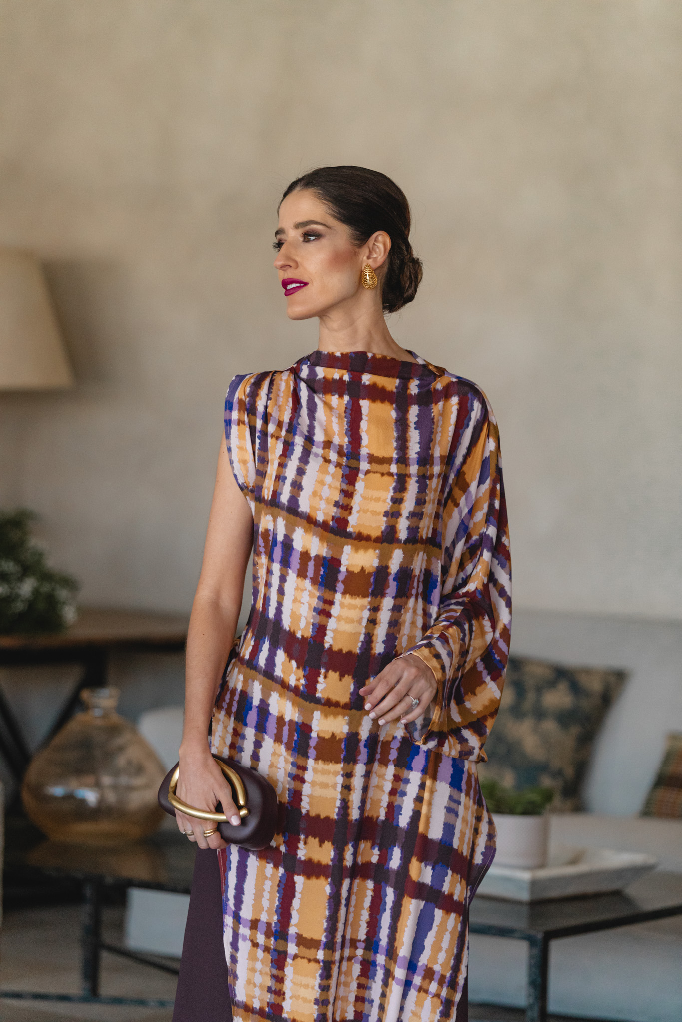 Invitada con blusón anudado y pantalón berenjena en interior decorado