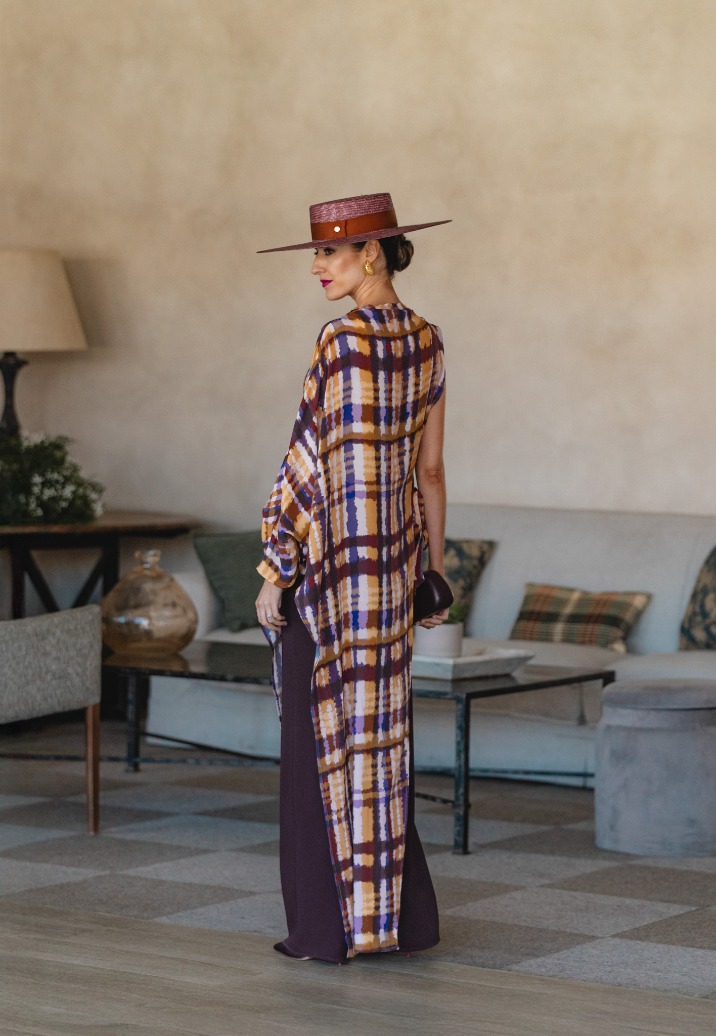 Look de invitada con túnica fluida y accesorios en burdeos