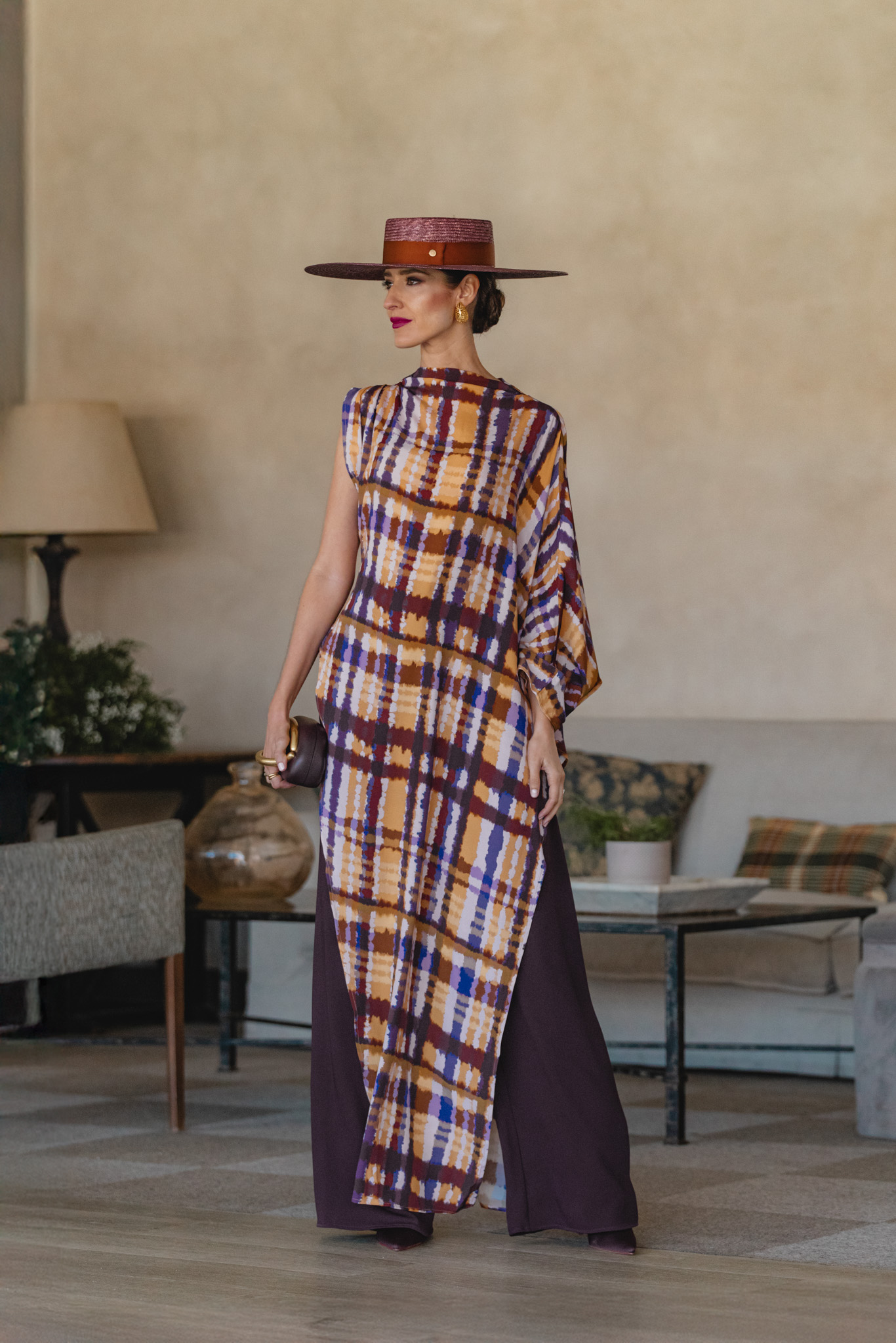 Invitada con blusa tipo túnica de colores mostaza y morados y pantalón ancho