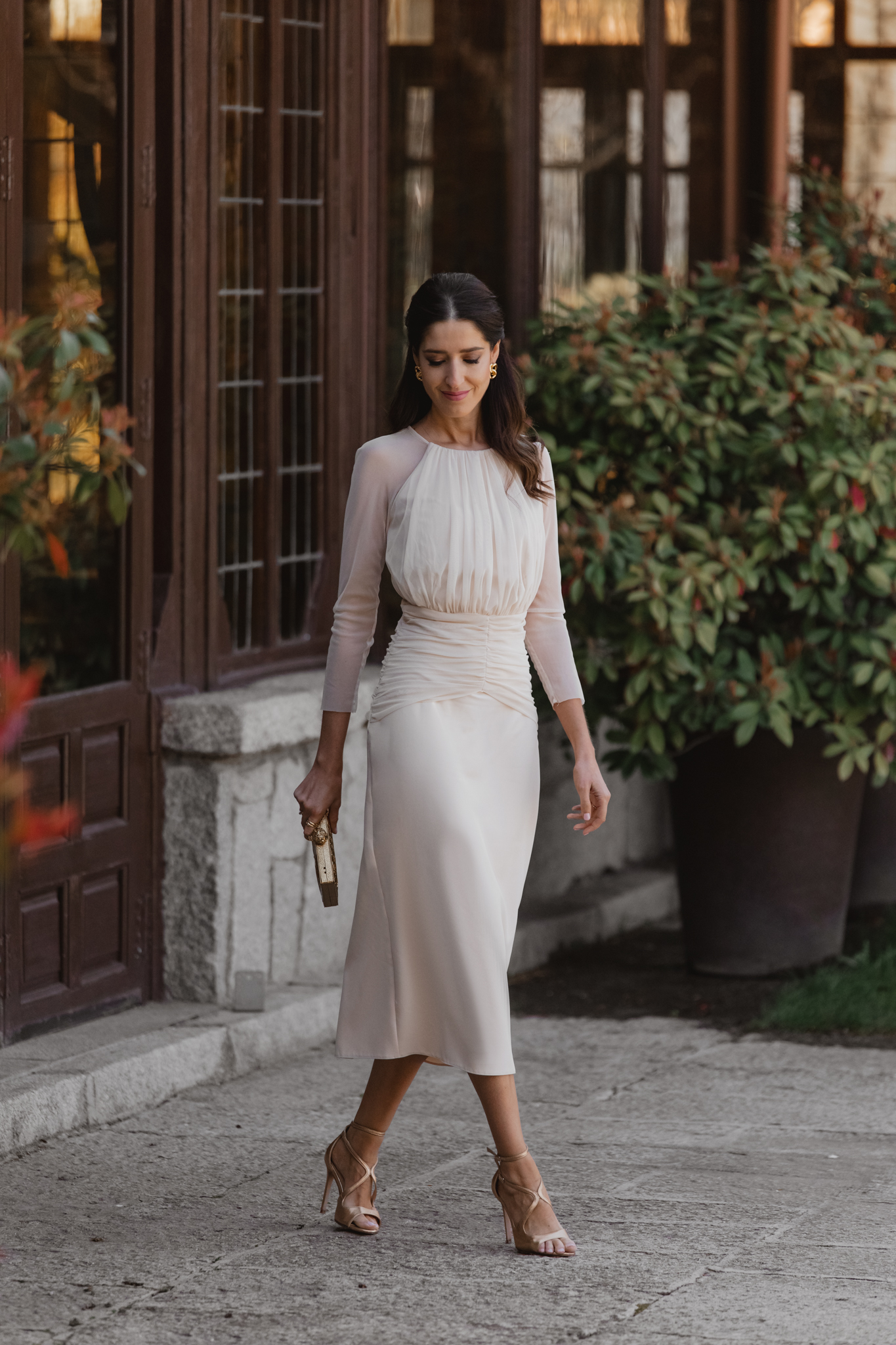 Vestido crudo de Invitadísima fotografiado en un ambiente rústico con plantas