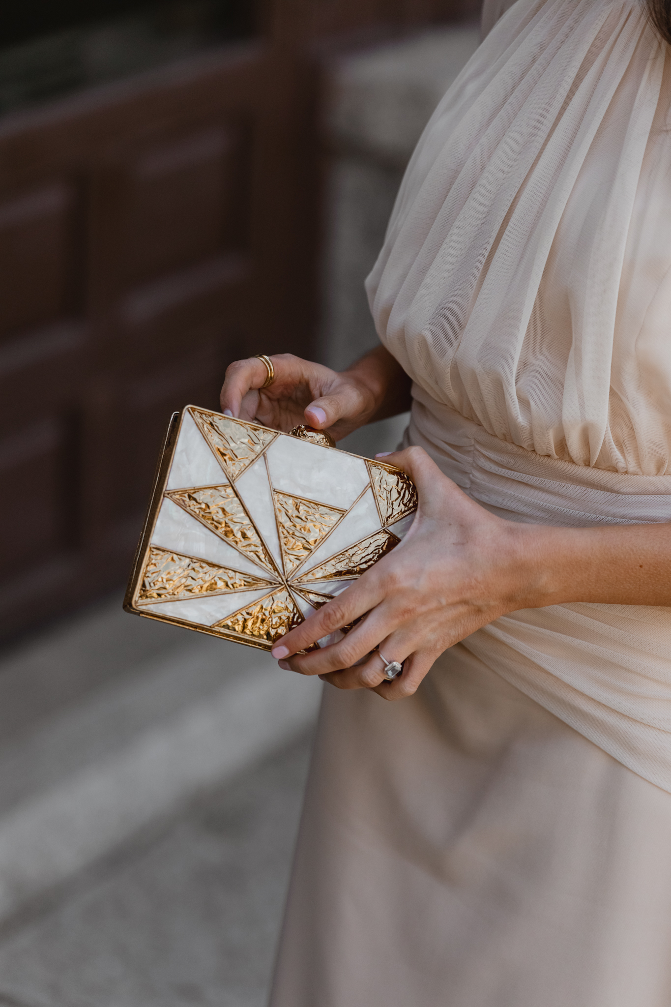 Bolso dorado de Occeanis combinado con vestido crudo para look de invitada