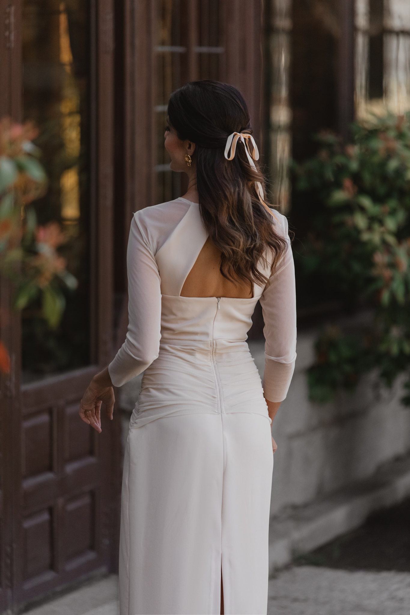 Detalle de la espalda del vestido crudo con tul plisado y peinado semirecogido