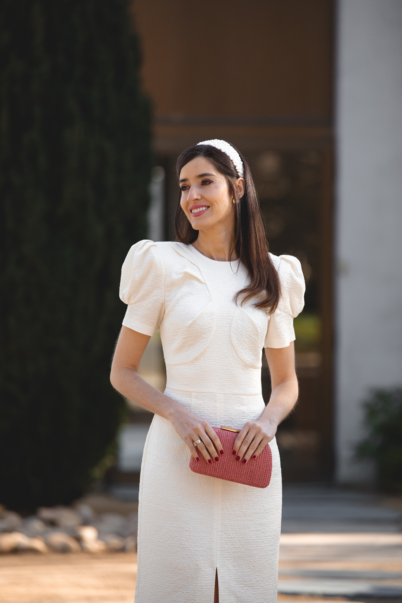 Mamá de comunión con vestido blanco roto de Meryfor y diadema de flores en exterior.