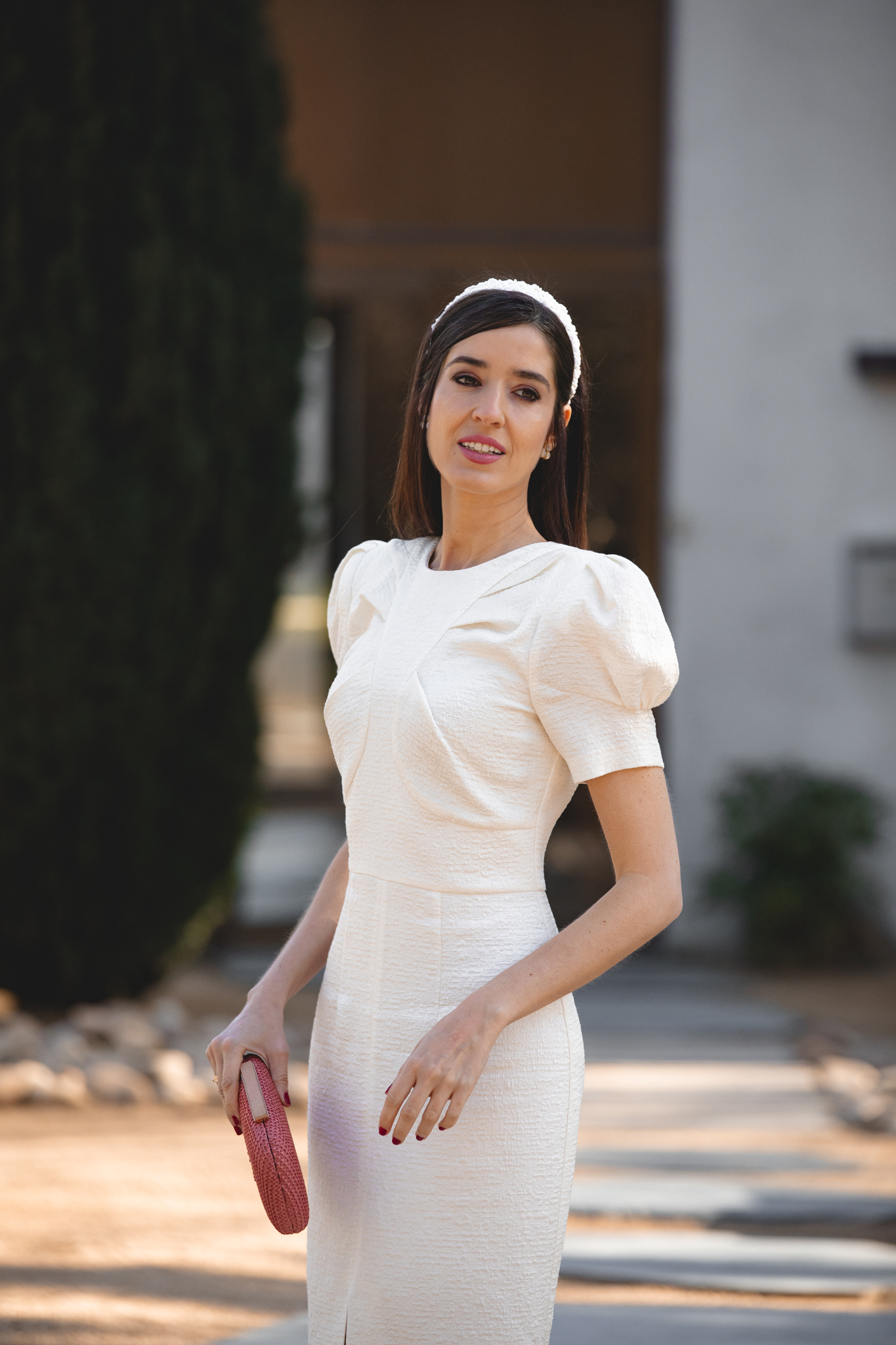 Vestido blanco roto con hombreras y mangas farol en estilismo de comunión.