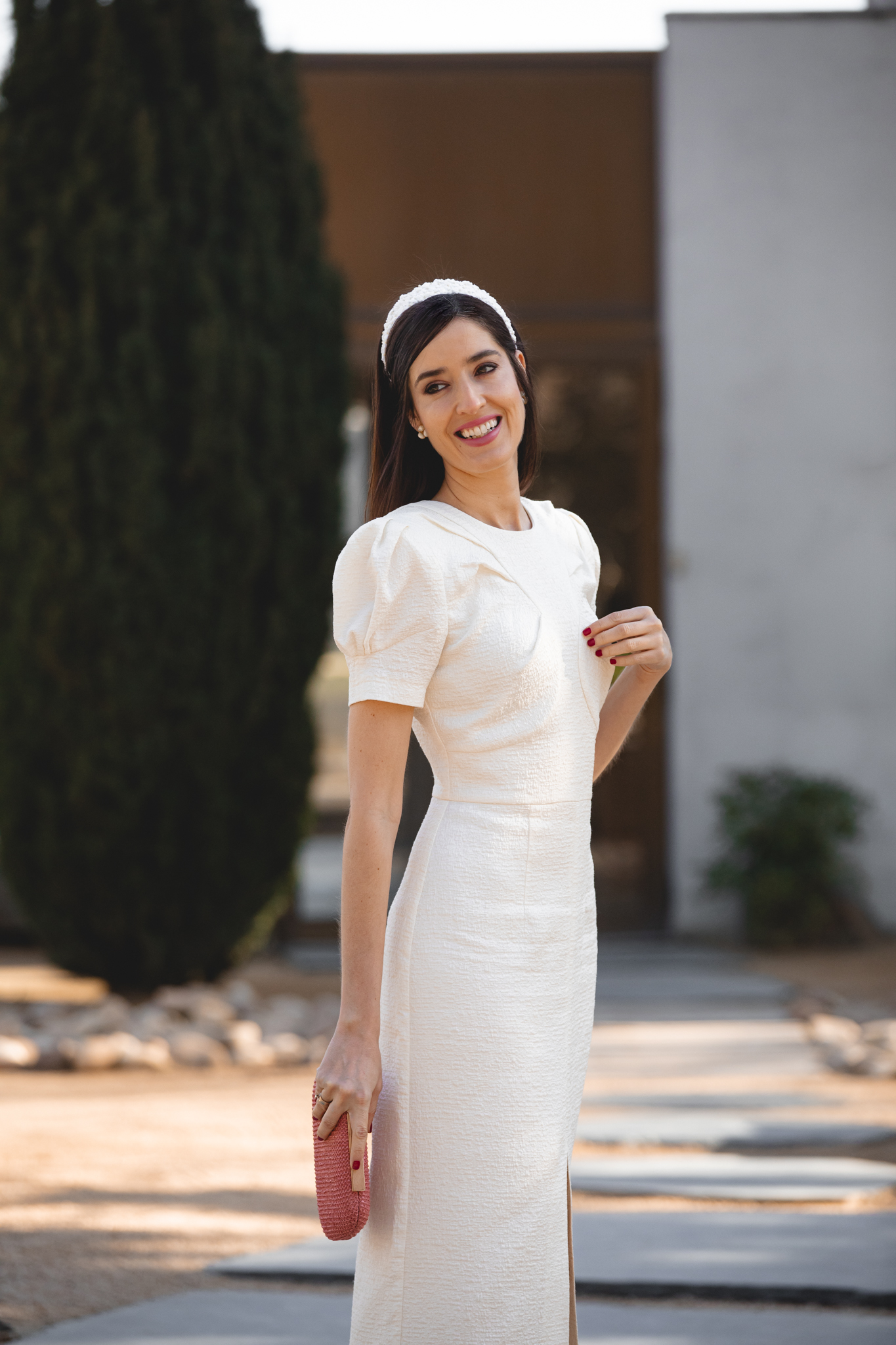 Mamá de comunión con look dulce en blanco roto y diadema blanca de flores.