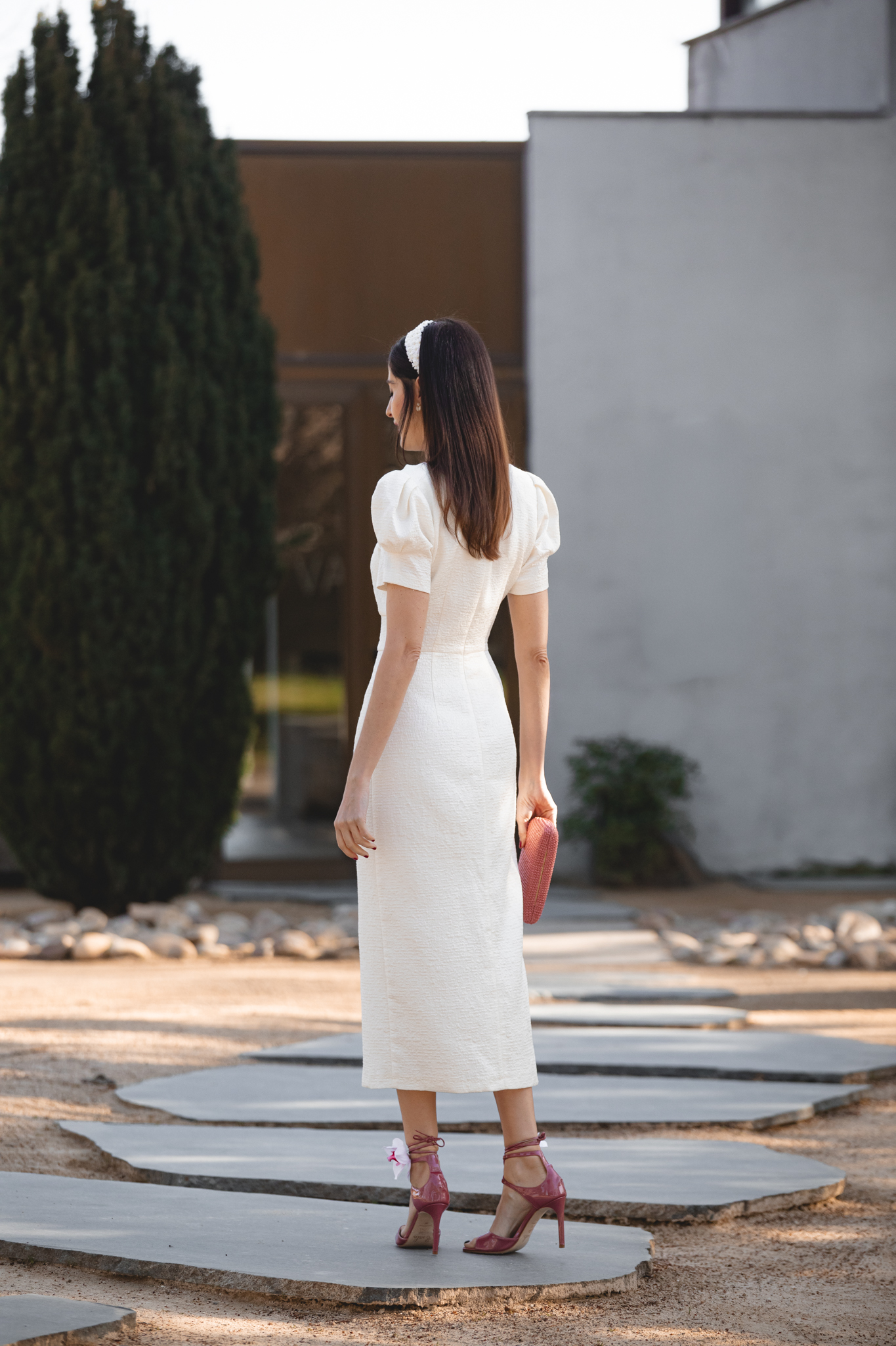 Look de comunión en blanco roto con diadema de flores y sandalias rosas