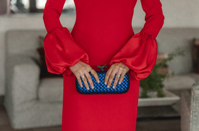 Primer plano de los puños farol del vestido rojo para invitada de boda.