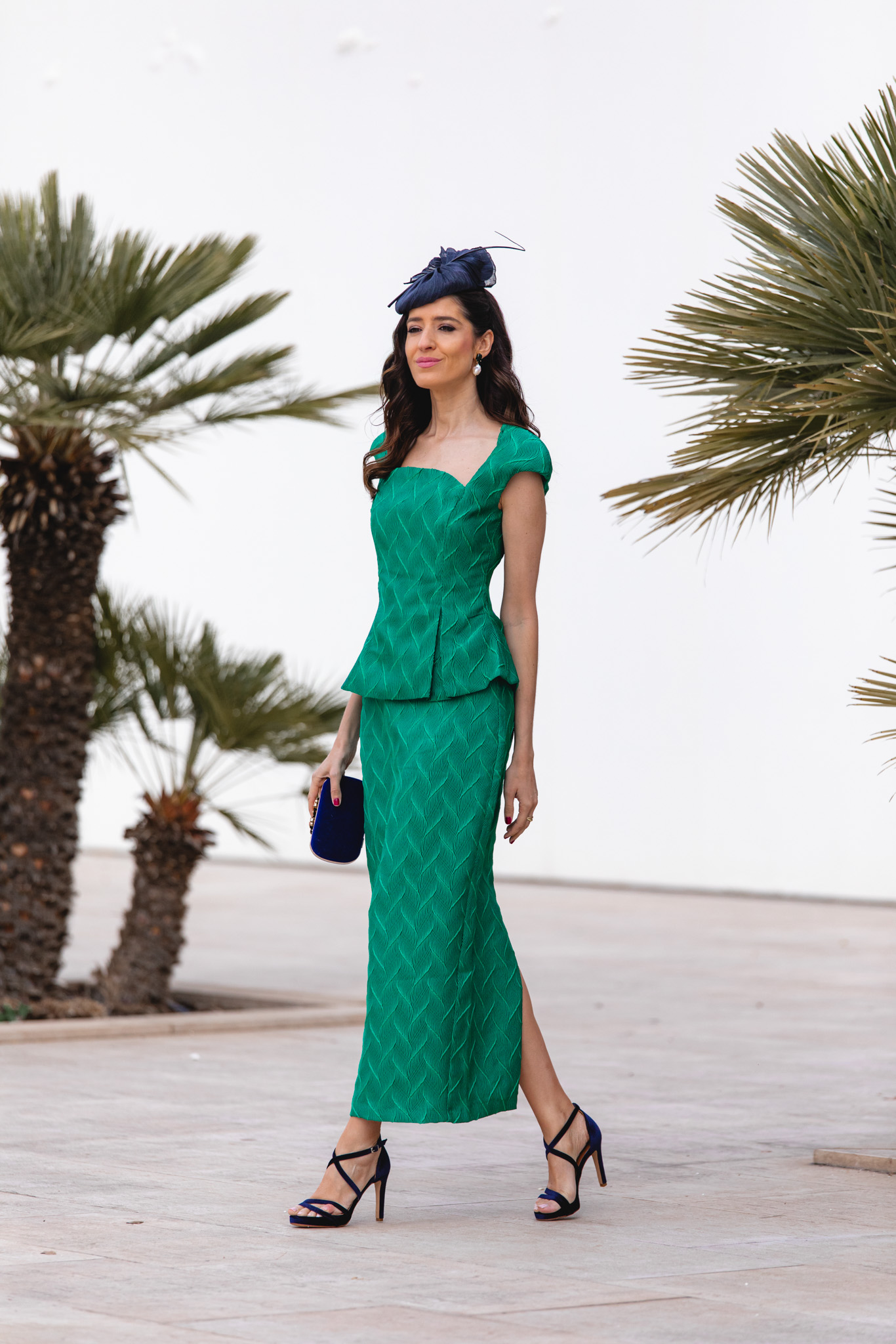 Look elegante en verde esmeralda con tocado azul y pendientes marinos.