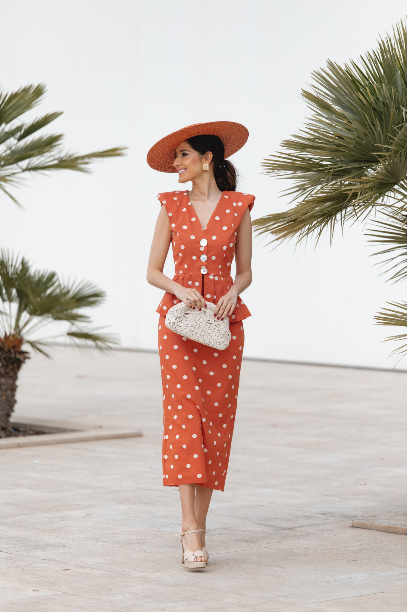 Vista completa del look de invitada en tono teja con pamela y accesorios cálidos.