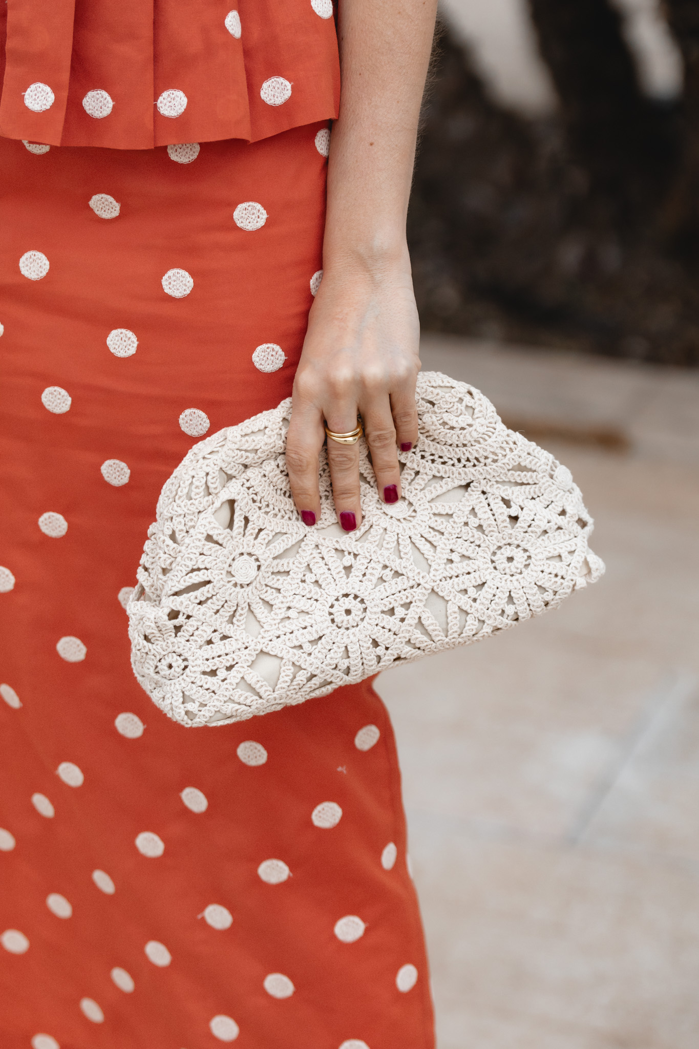 Bolso de ganchillo beige de Marcela & Co en estilismo de invitada elegante y relajado.