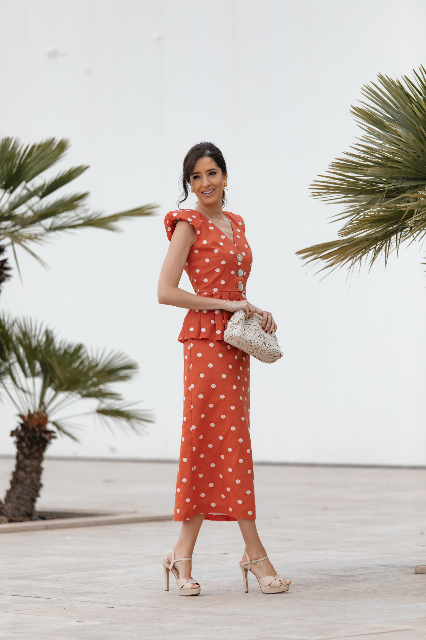 Top peplum teja con escote en V y falda midi a juego en estilismo de invitada.