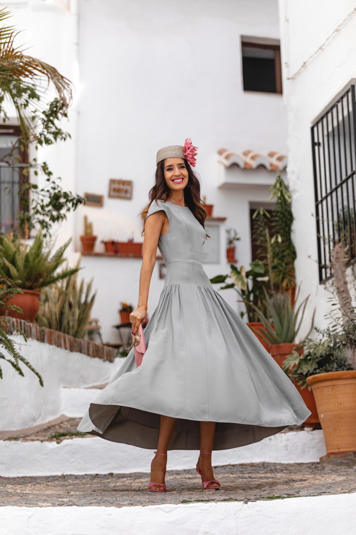 Movimiento de la falda gris perla mientras la invitada sube una escalera mediterránea.