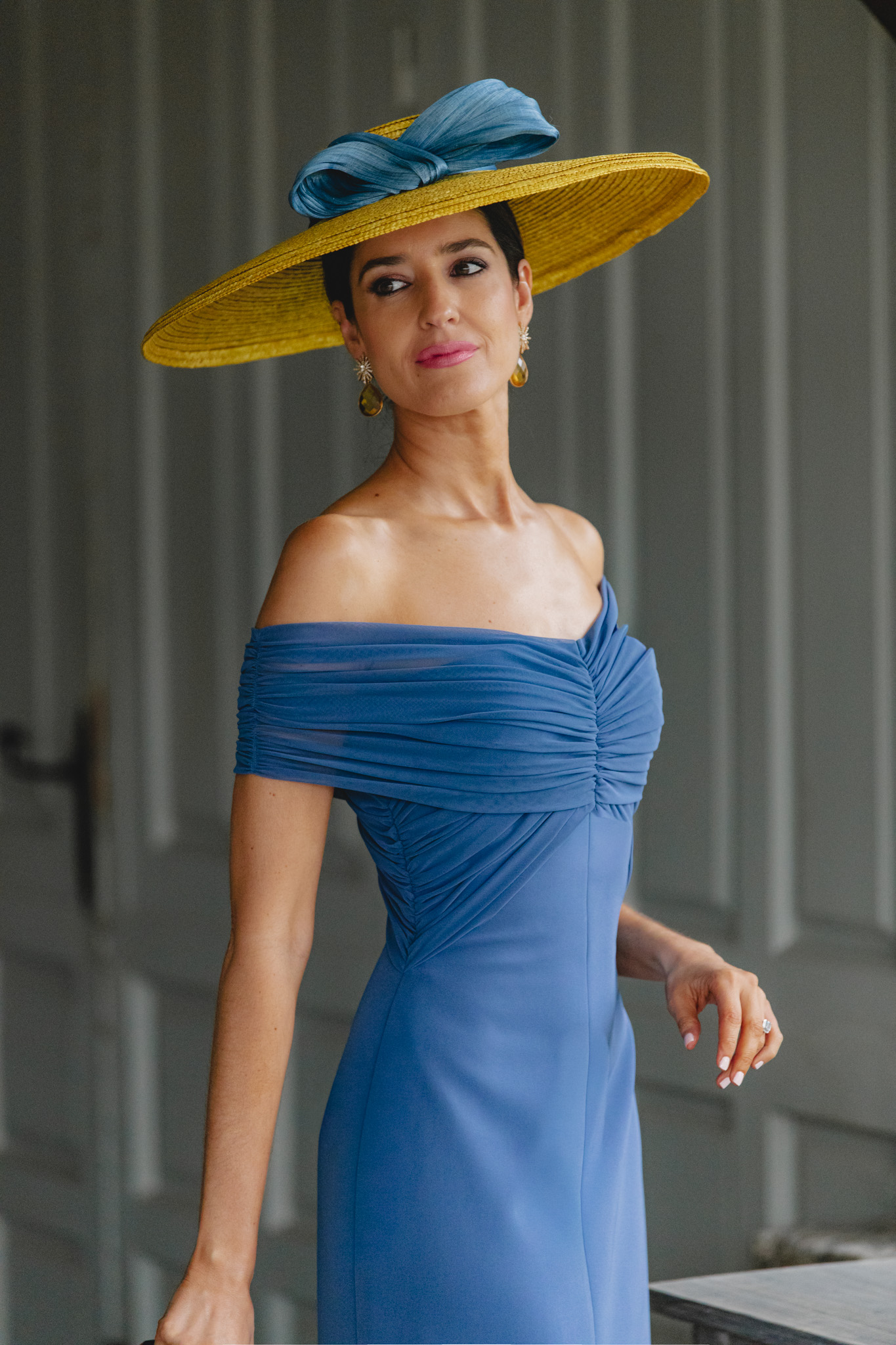 Vestido azul bardot para invitada elegante con pamela amarilla.