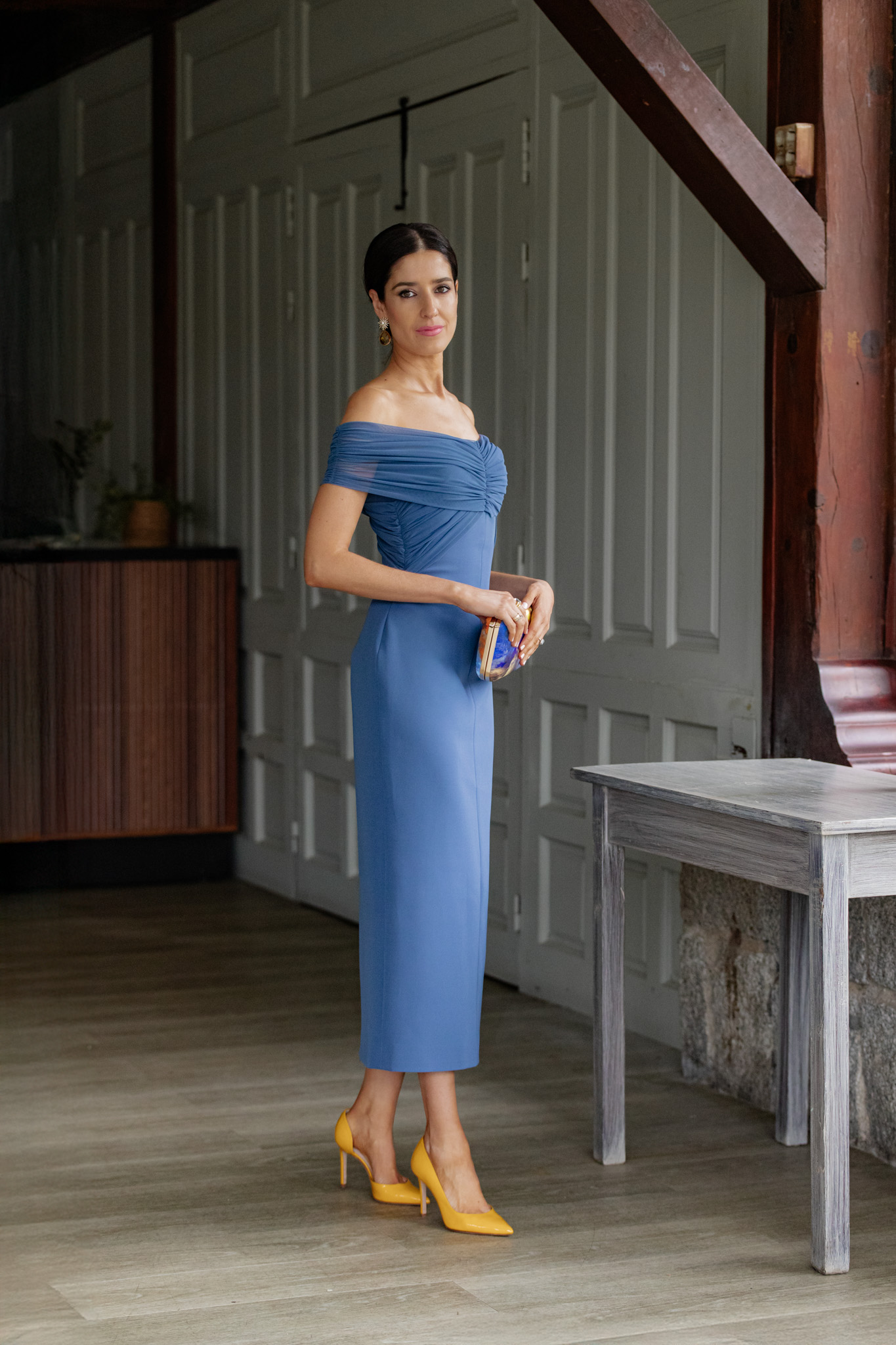 Look de invitada perfecta con vestido azul y accesorios en amarillo.