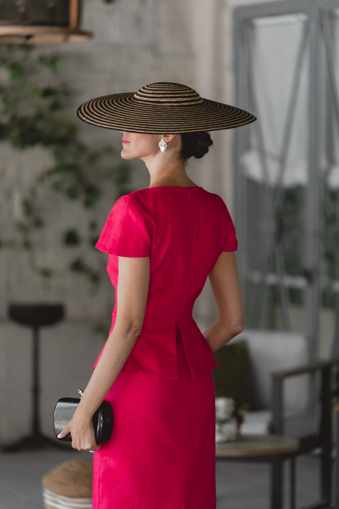 Sandra Majada con look sofisticado de invitada y pamela negra.