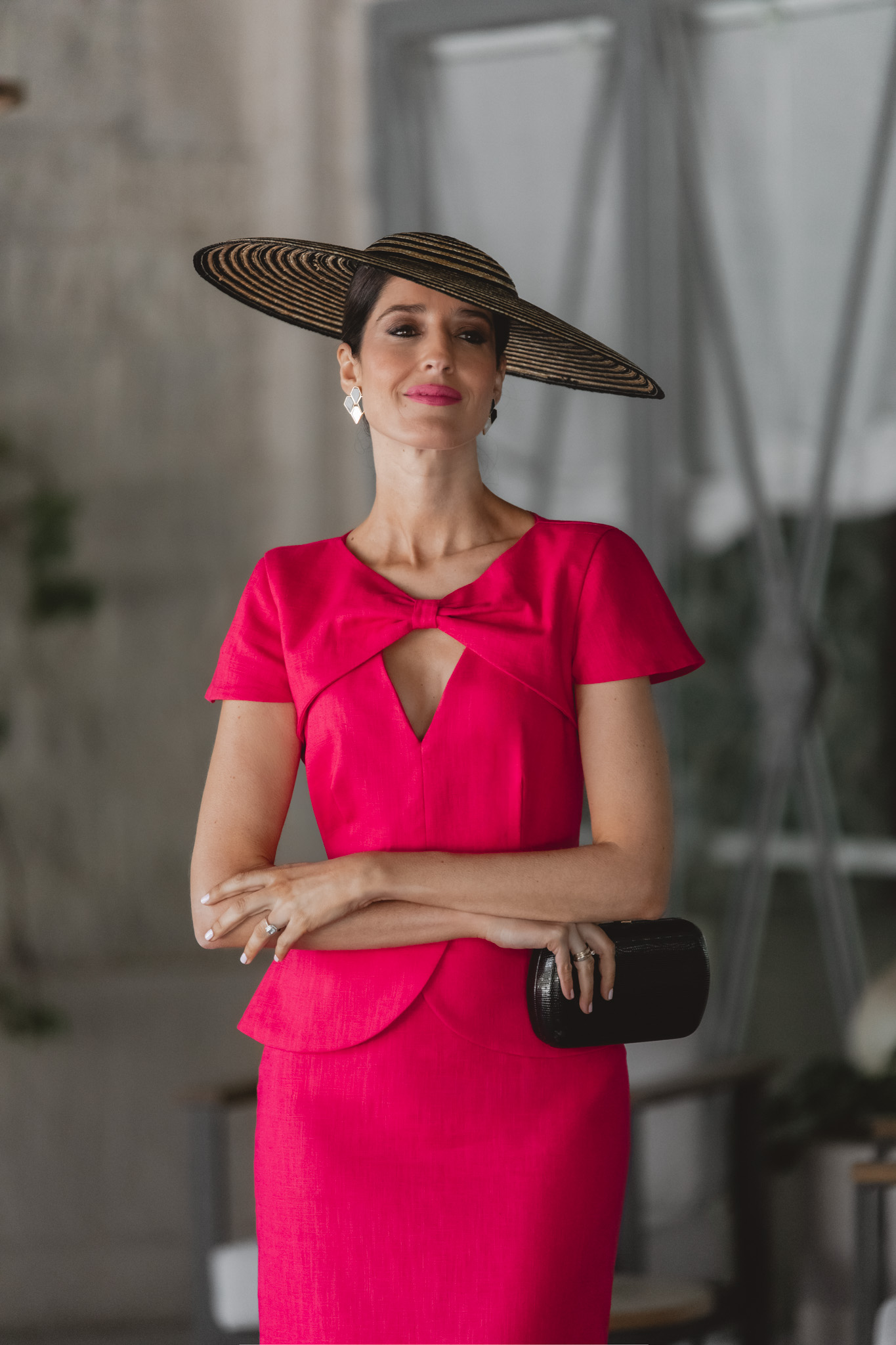Invitada perfecta con vestido de lino fresa y pamela en paja y negro.
