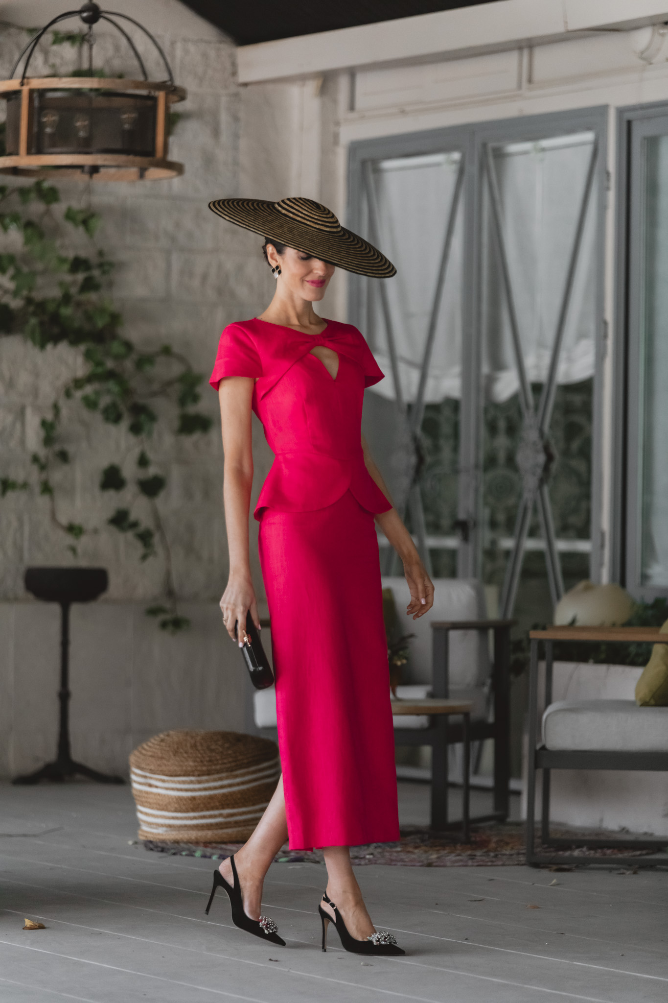 Look de invitada de mañana con vestido de lino fresa y pamela negra.
