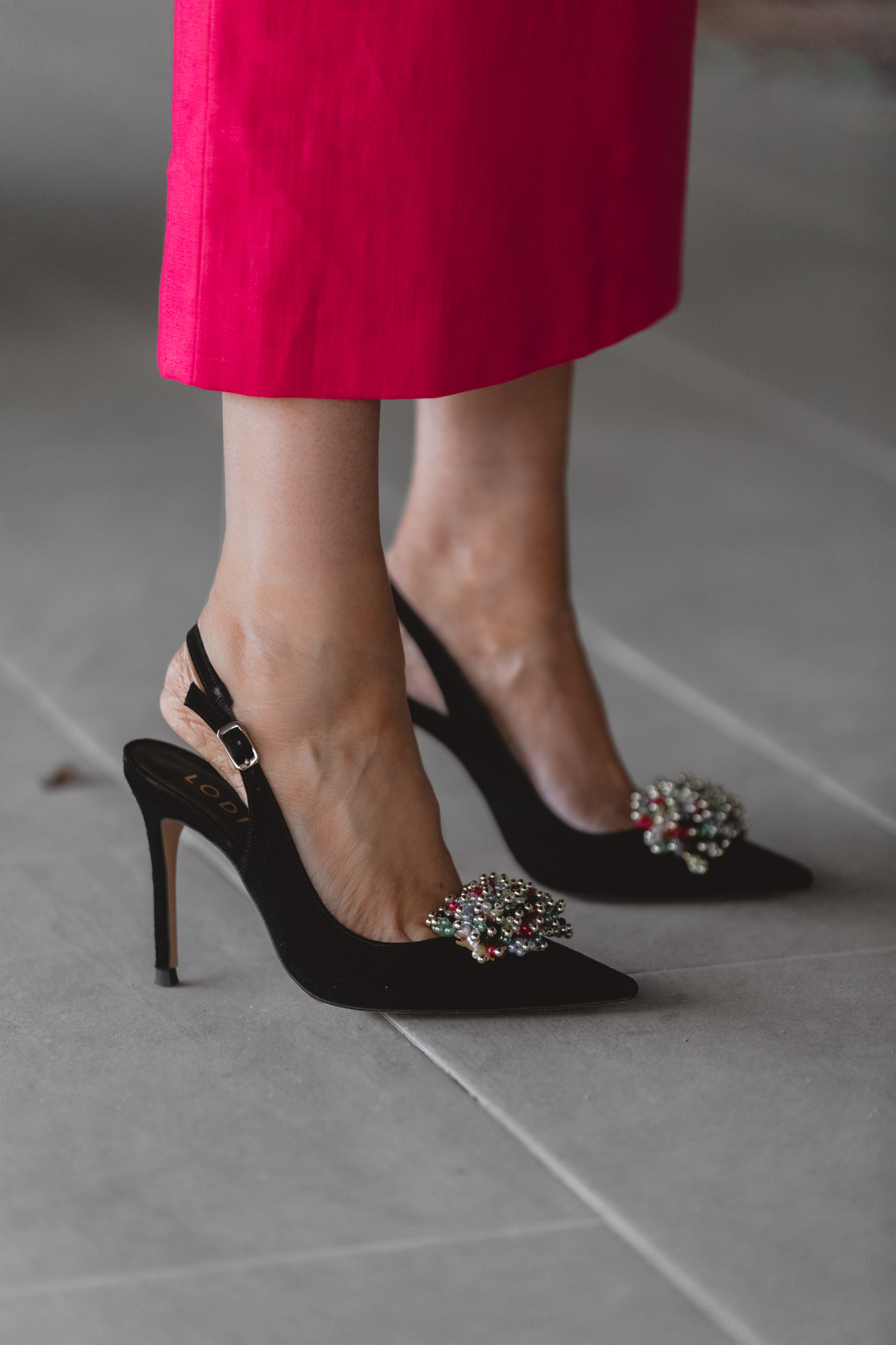 Detalle de zapato salón con joya multicolor para invitadas elegantes.