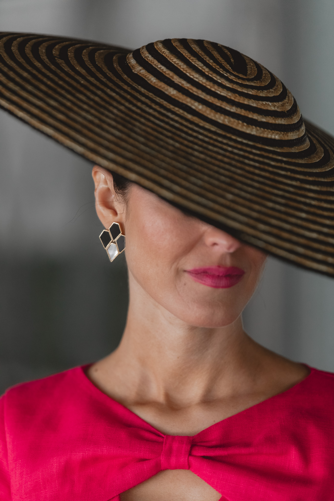Detalle de pendiente blanco y negro de Acus en look de invitada perfecta.