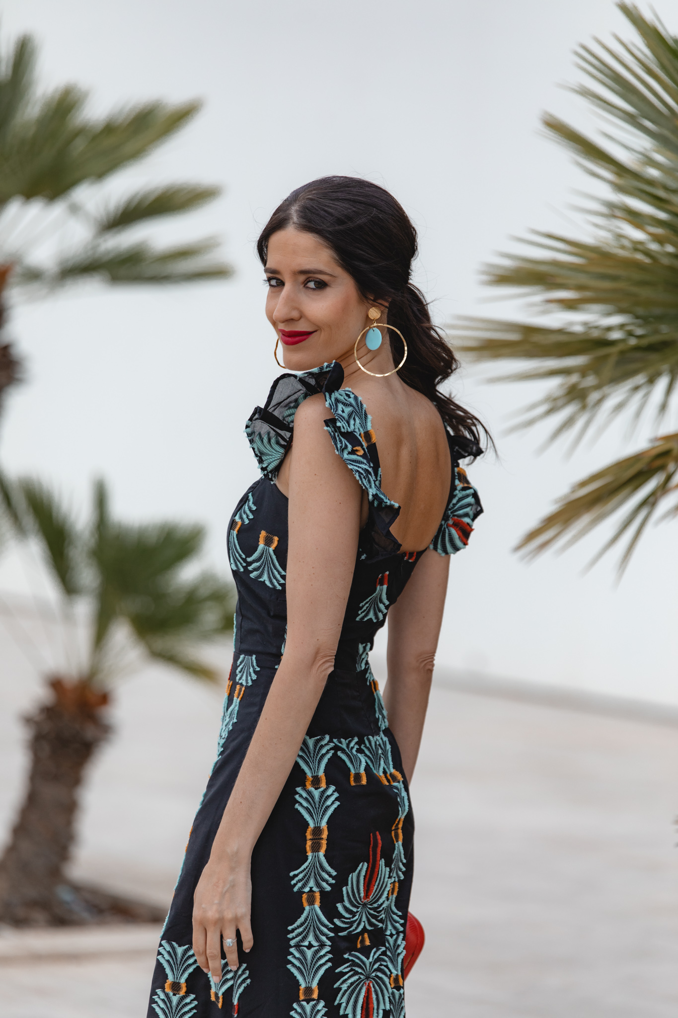 Invitada de boda con coleta baja con ondas y labios rojos