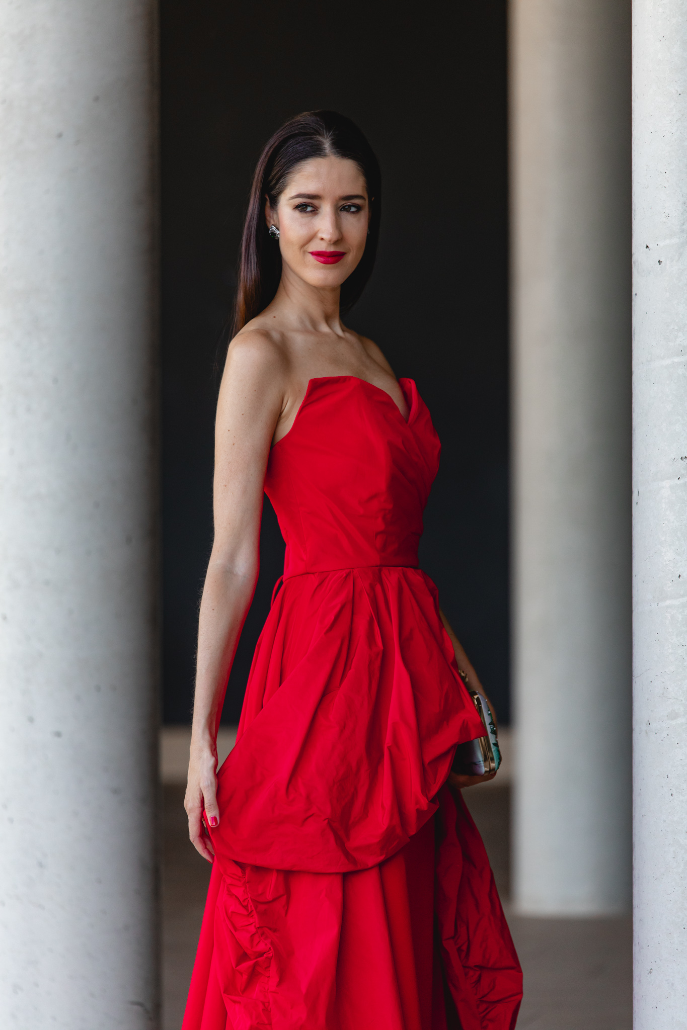 Vista lateral del vestido largo rojo con sobrefalda peplum en movimiento