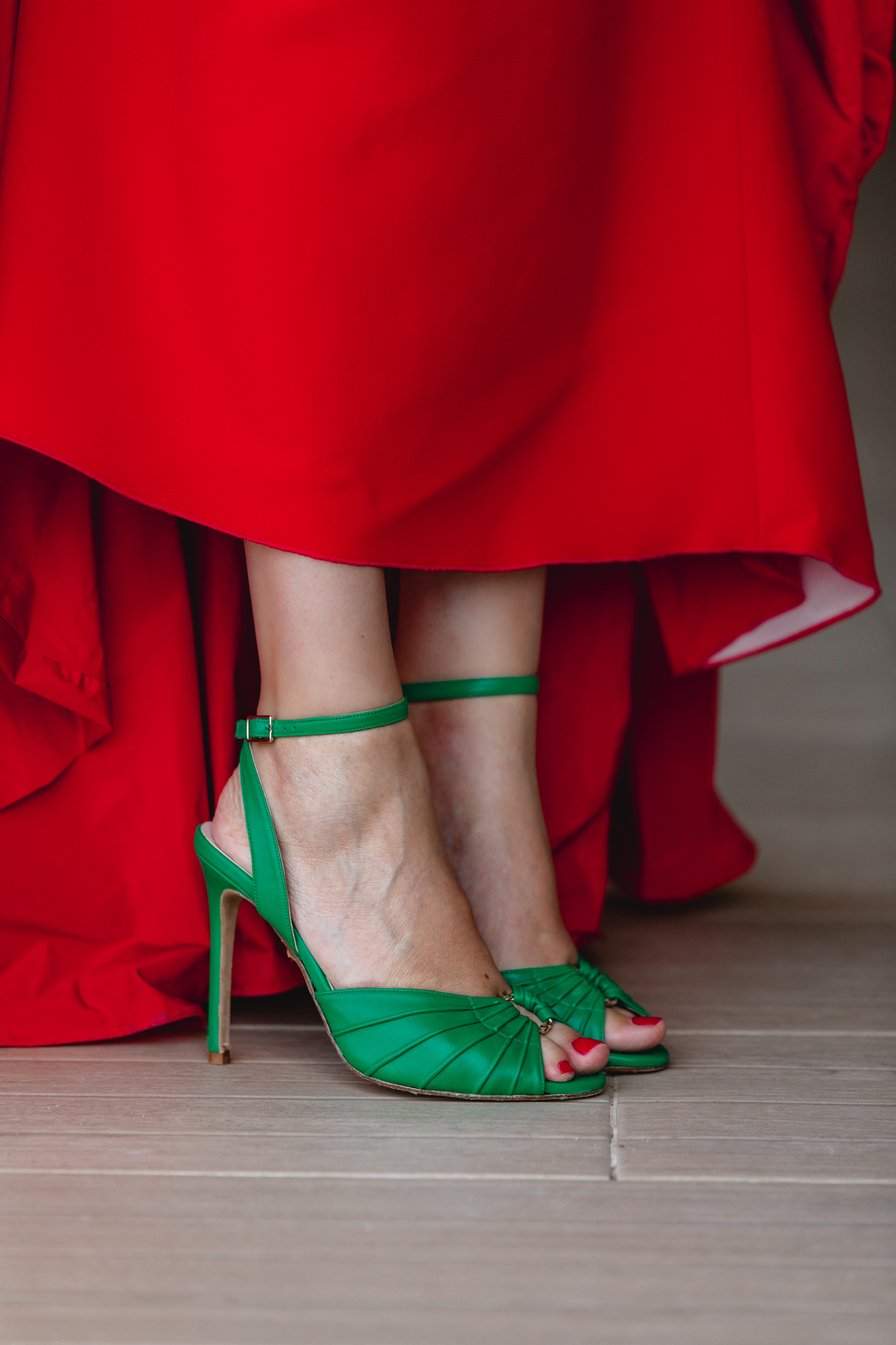 Detalle de las sandalias verdes satinadas de Salo Madrid con vestido largo rojo