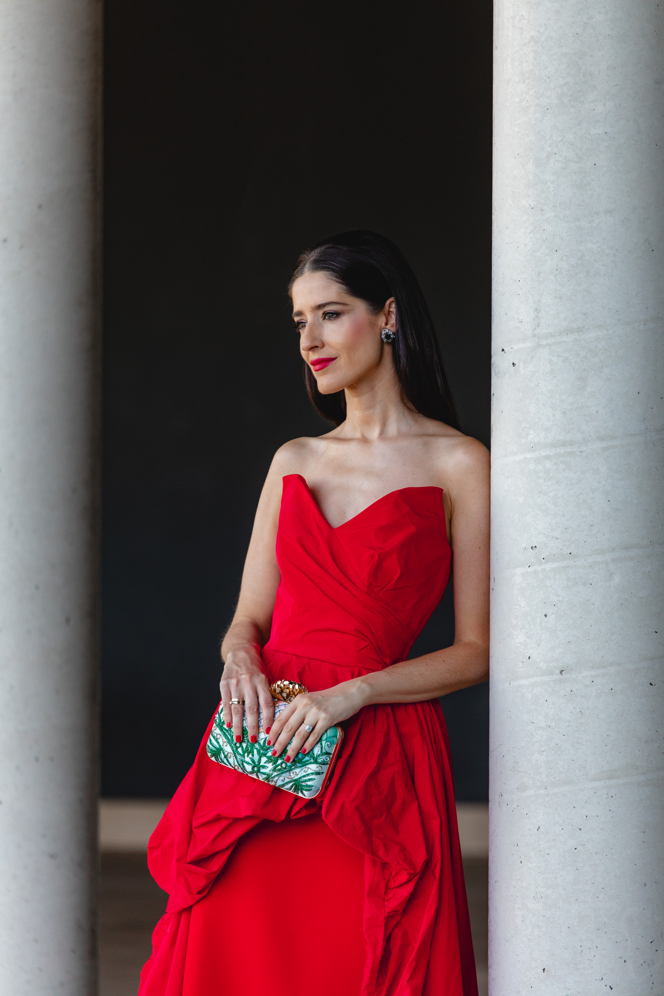 Plano medio de invitada con vestido largo rojo palabra de honor y escote corazón