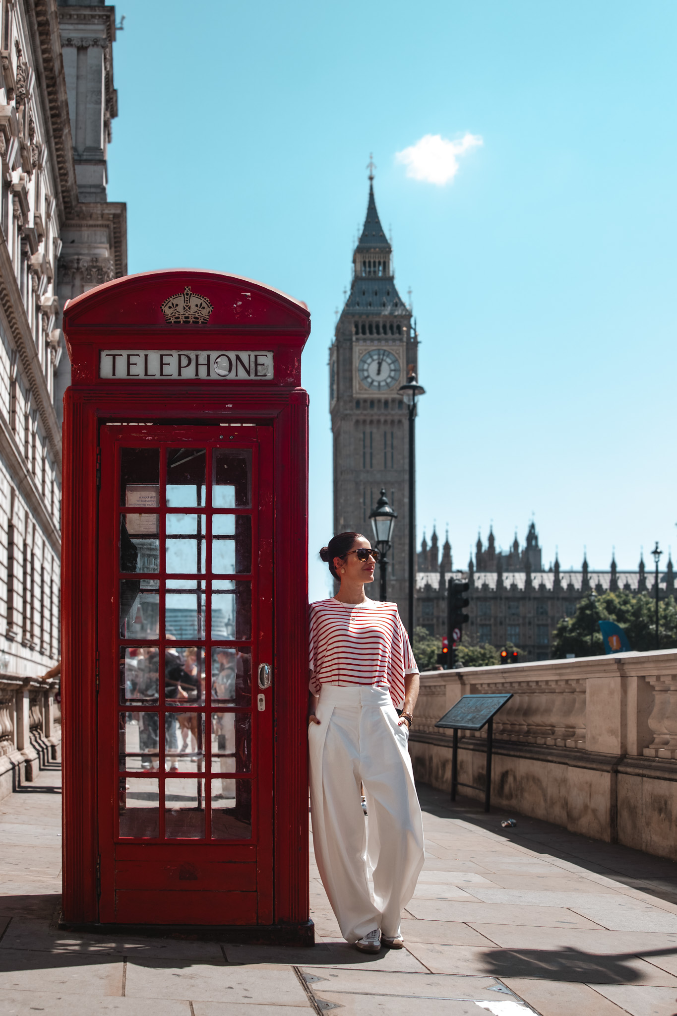 Mujer junto a una cabina telefónica roja con el Big Ben al fondo, Londres
