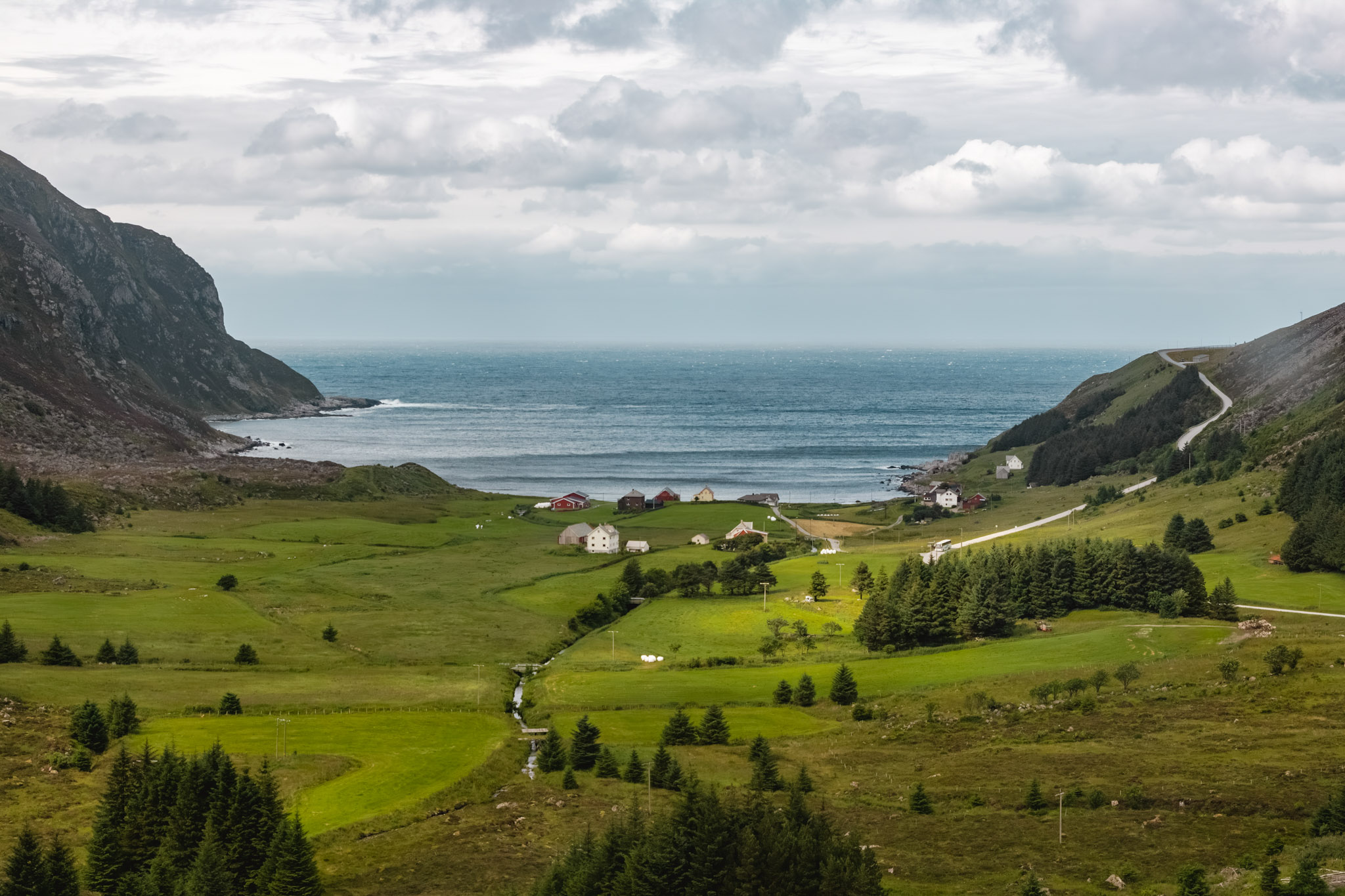 Paisaje costero de fiordos verdes con un pueblo junto al mar