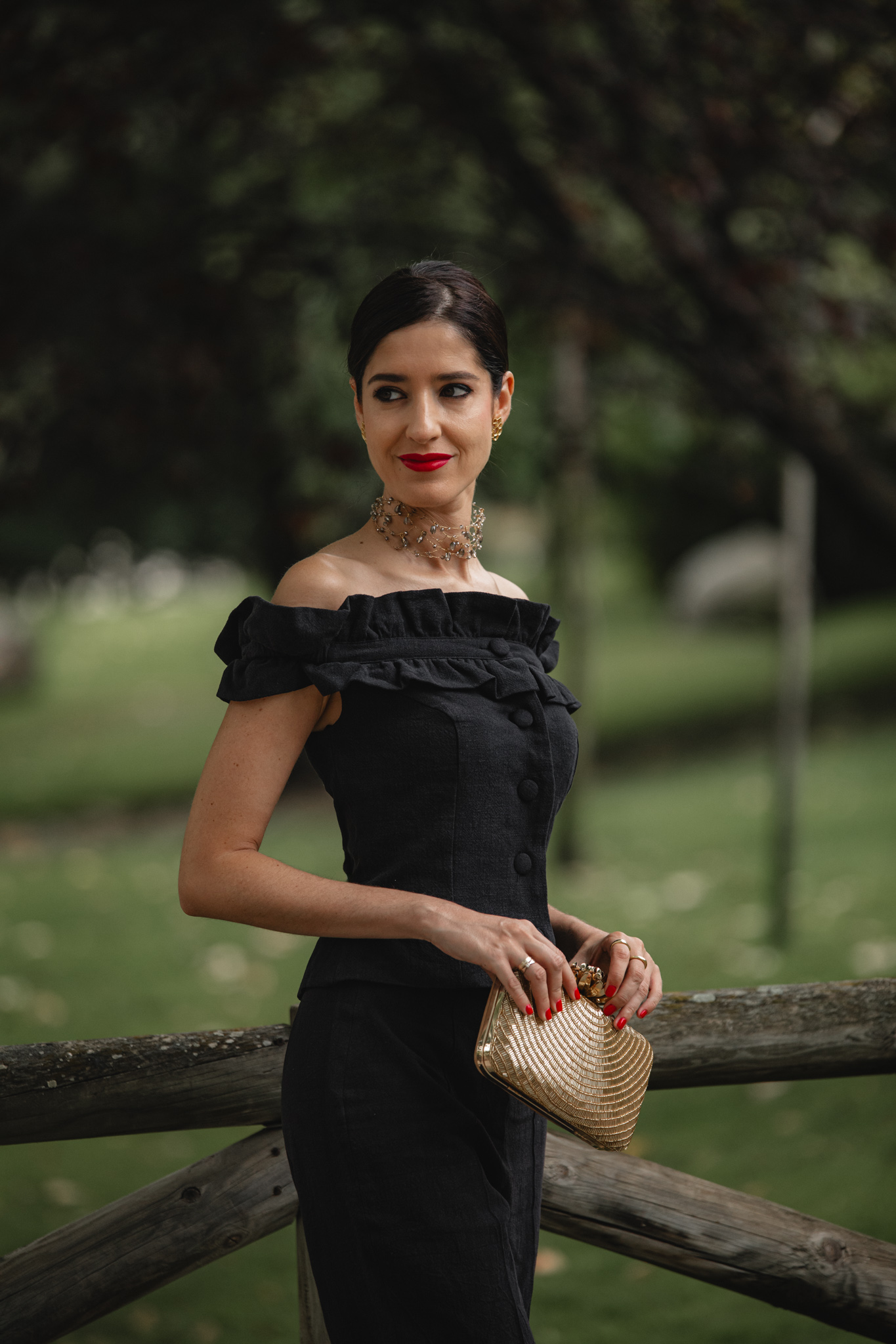 Detalle del conjunto pantalón de Cherubina con la invitada sujetando el clutch dorado